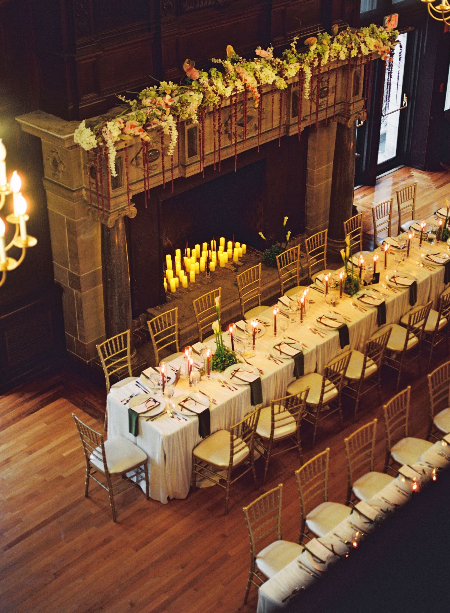 Overhead view of an elegant wedding reception setup with white tablecloths and gold chiavari chairs.