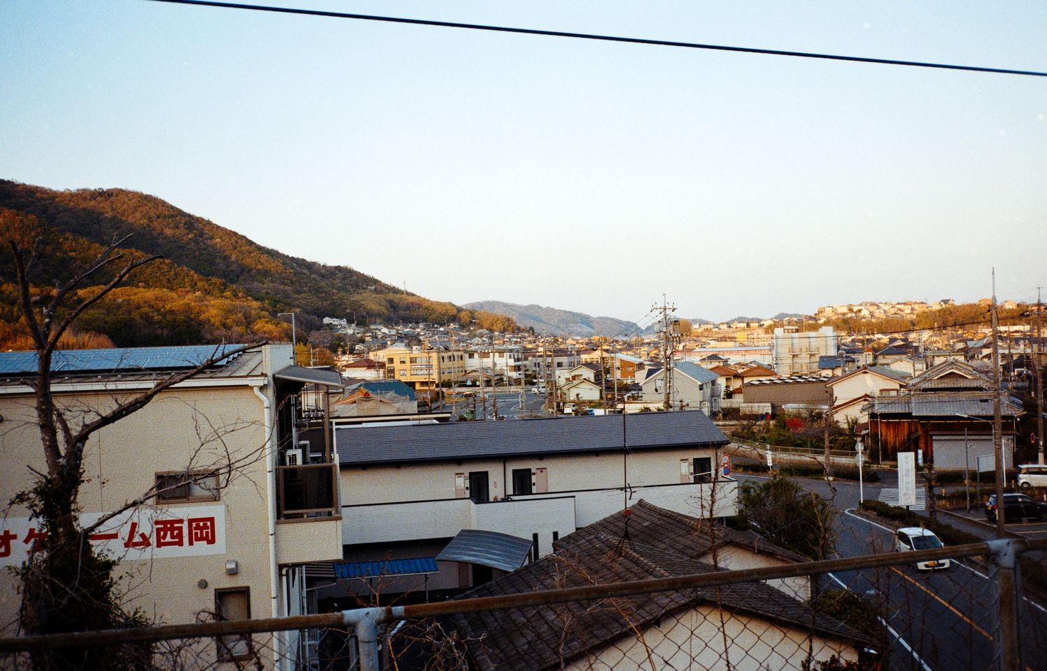 Aerial view of a coastal Japanese town with mountains in the background.