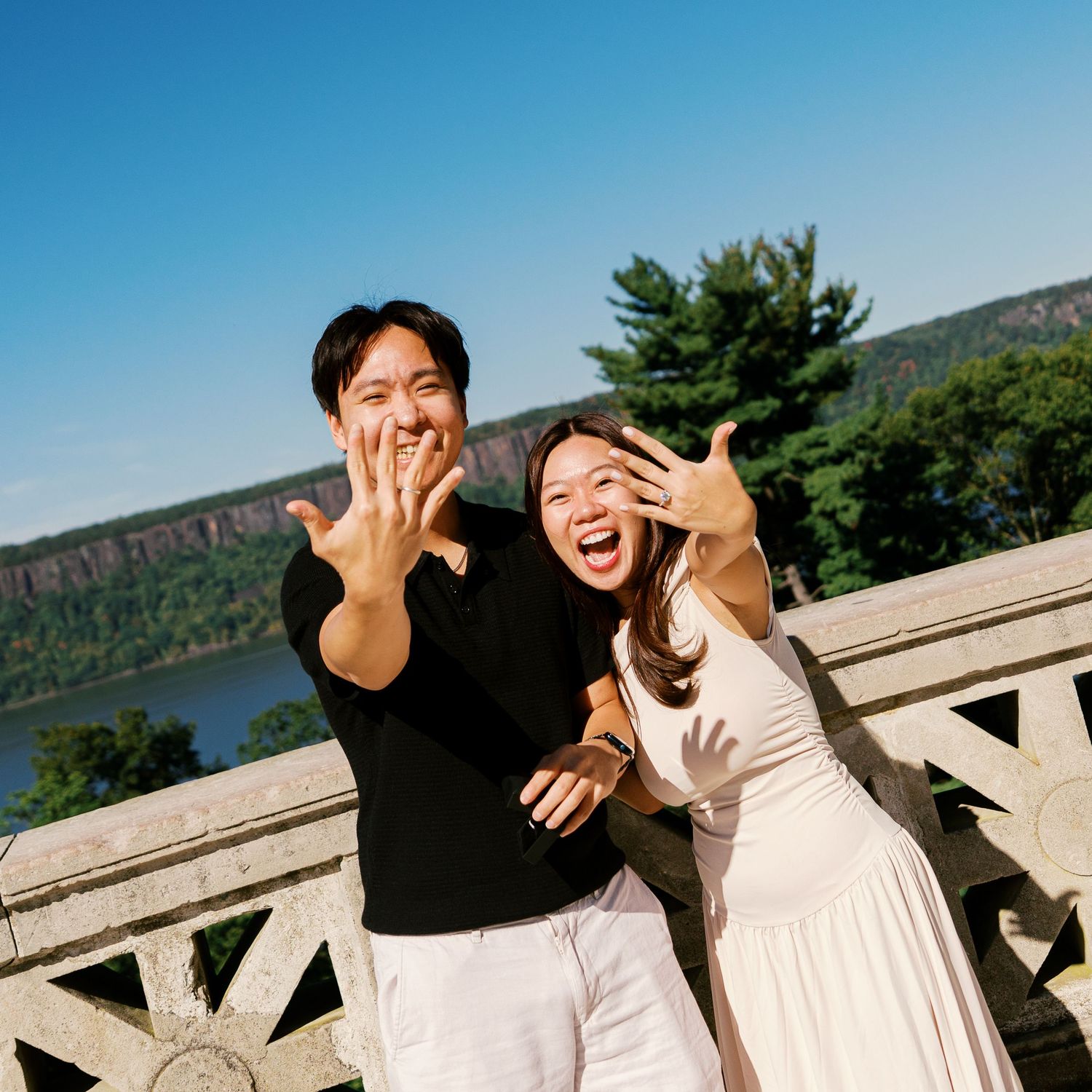 Joyful celebration captured against a scenic mountain backdrop with dramatic cliffs.