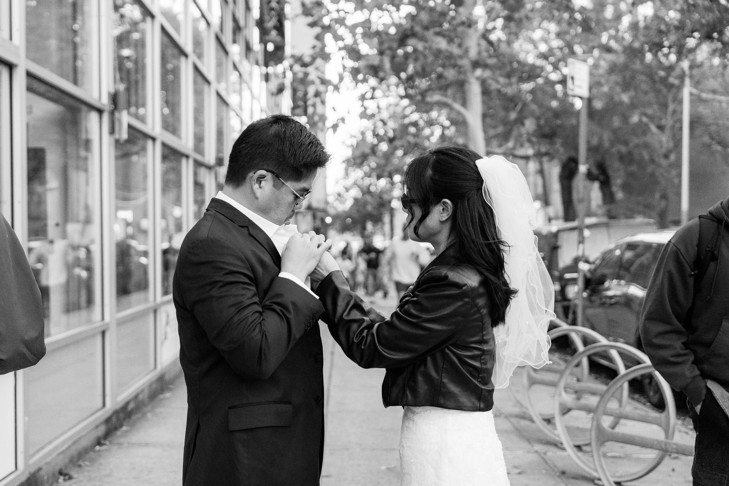 An outdoor wedding sequence with urban architecture in the background.