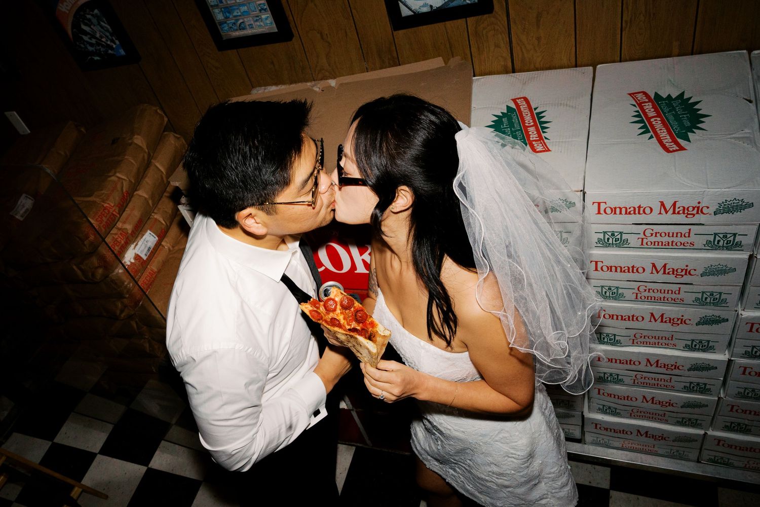 Wedding guests enjoying pizza from stacked delivery boxes at an informal reception.