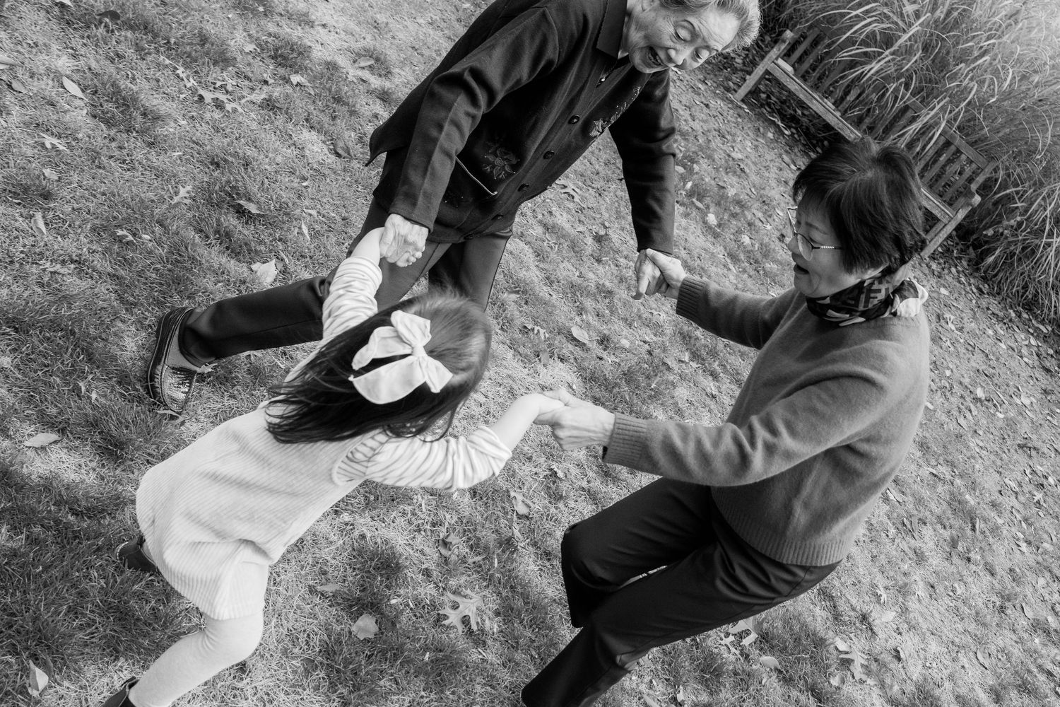 Black and white photo of two people playing on a blanket outdoors.