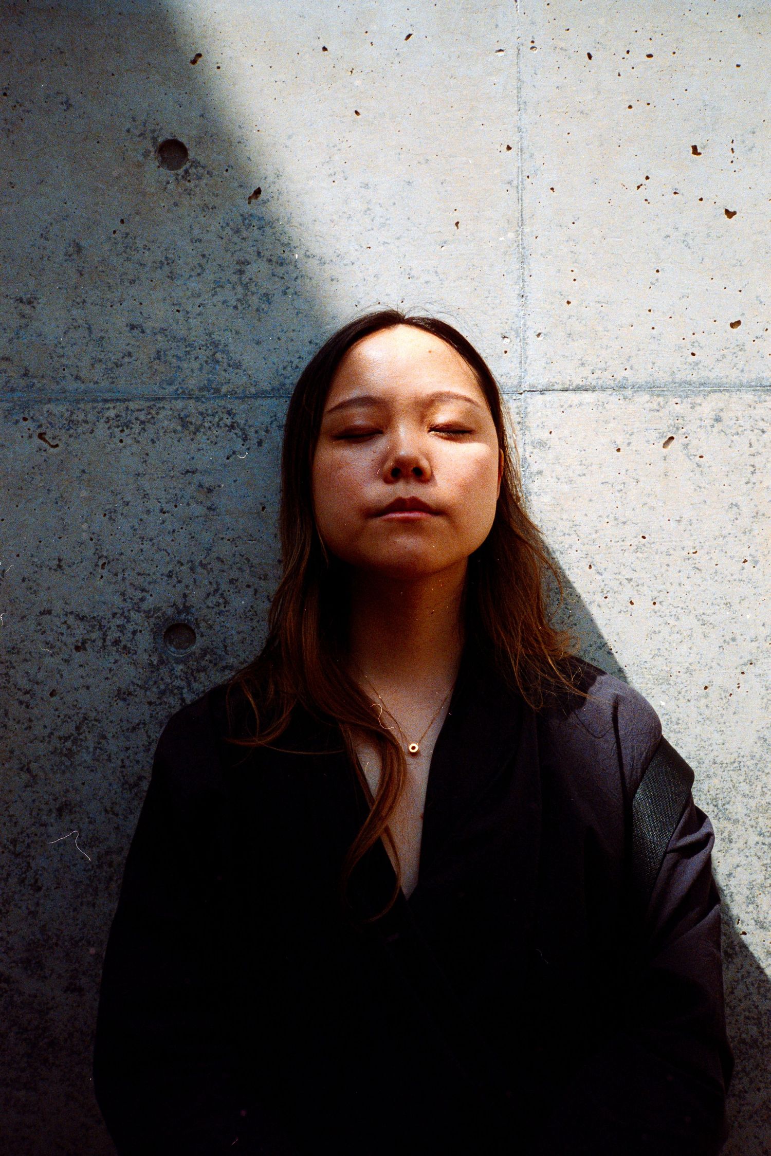 Artistic portrait series against a concrete wall showing shifting shadows and lighting.