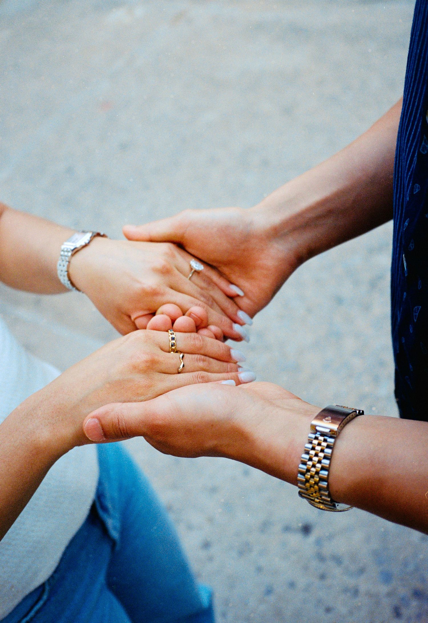 Close-up of hands with rings and watches showing an intimate moment.