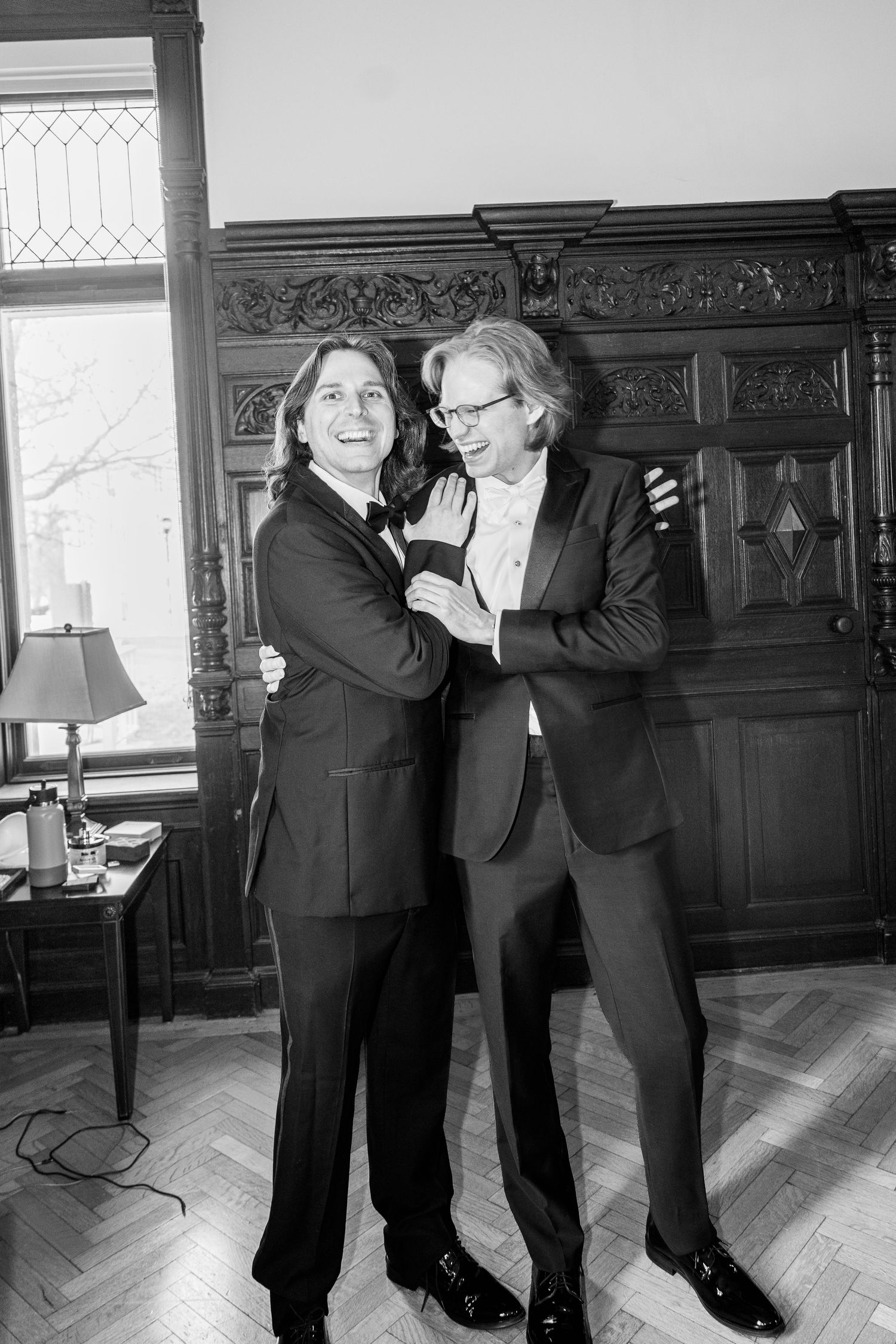 Black and white photo sequence showing two people in suits dancing and having fun in an elegant room.