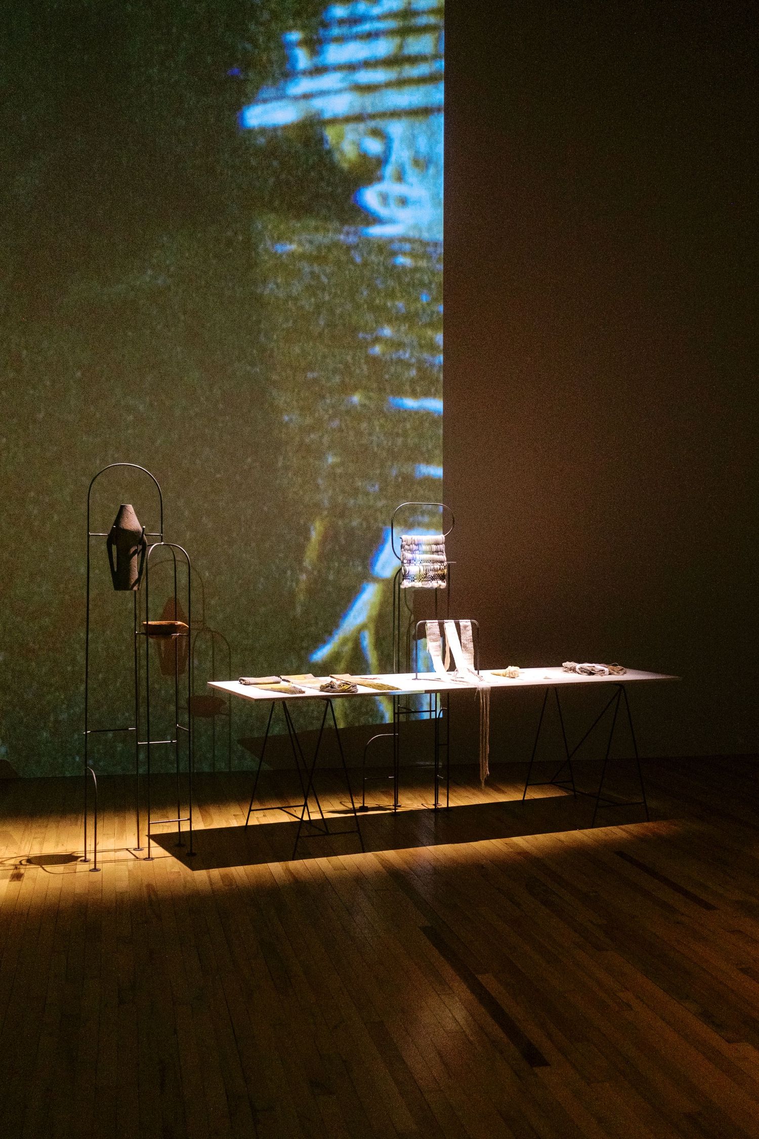 Dark stage setup with illuminated table and equipment creating dramatic shadows and lighting effects.