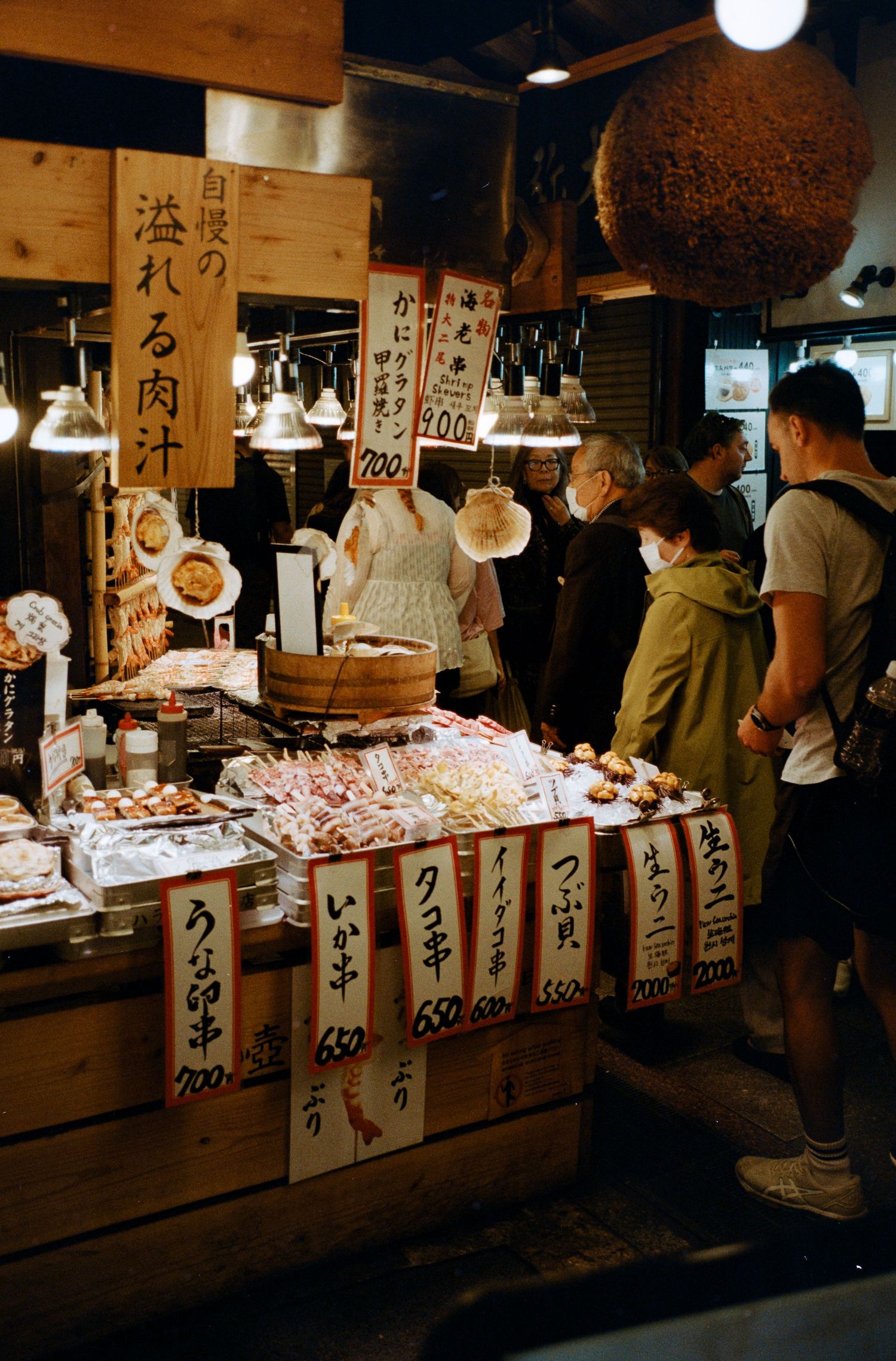 Traditional Japanese market stalls with vendors selling fresh seafood.