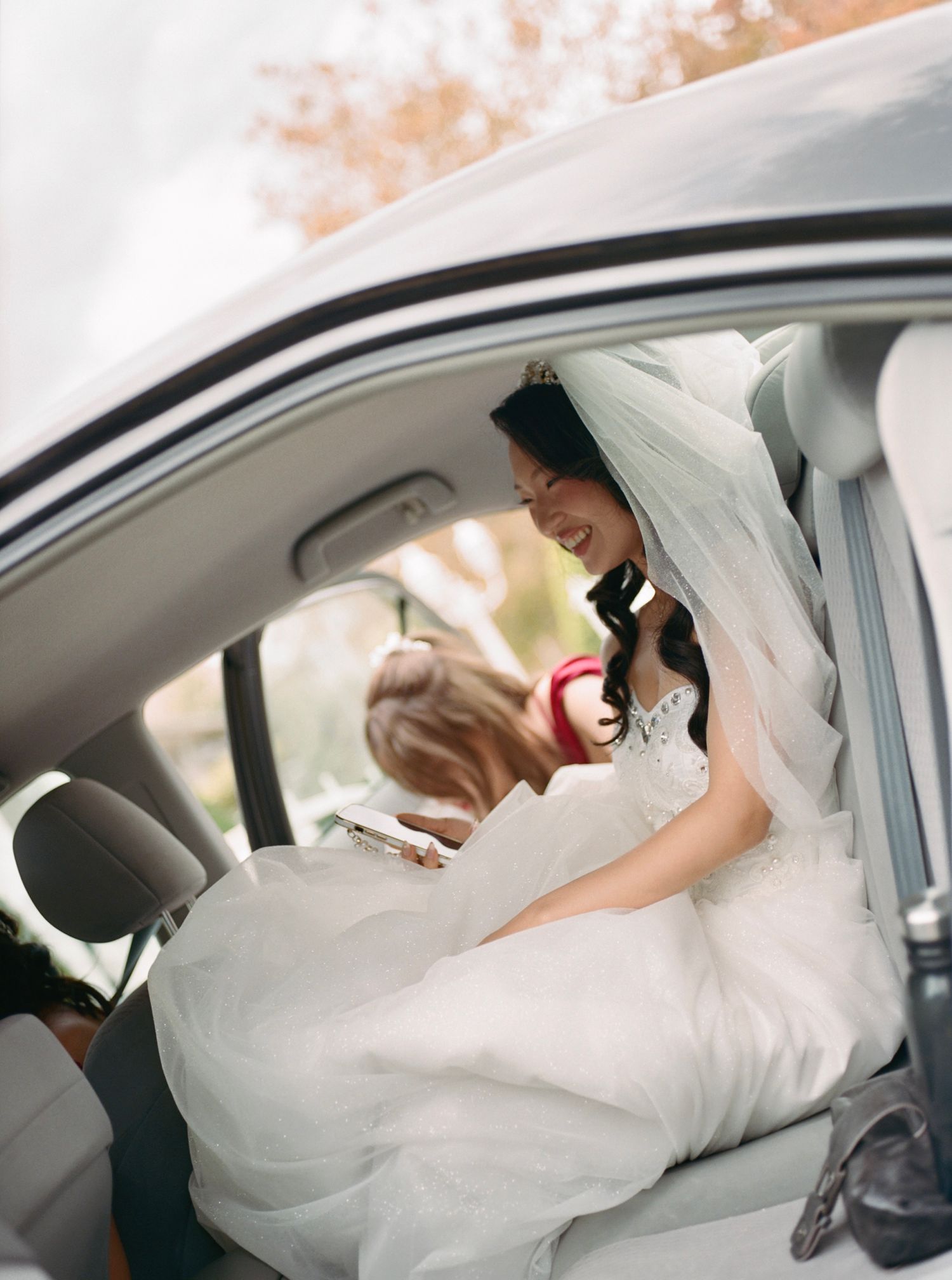 White wedding dress flowing elegantly inside a car.