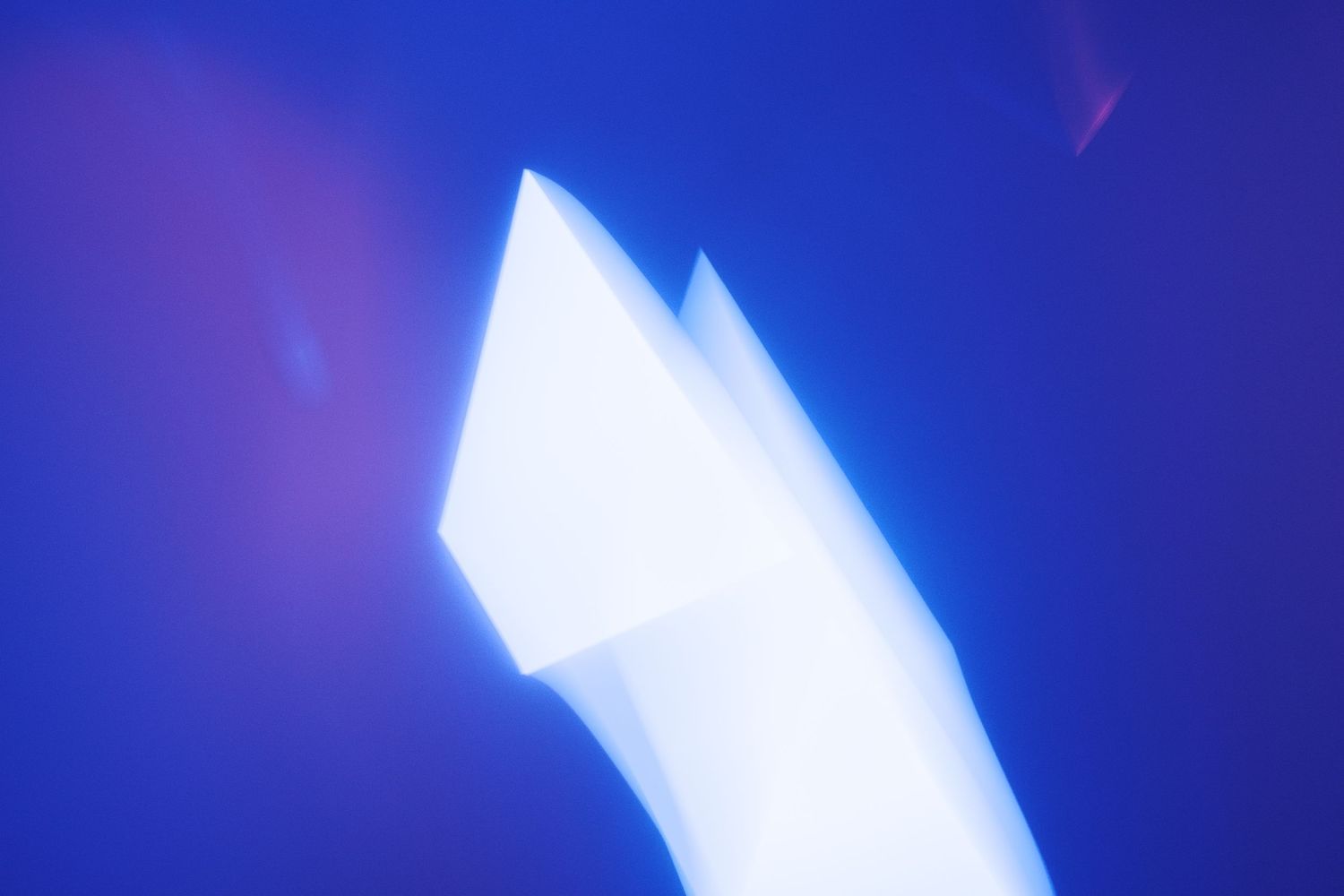 Glowing white light streaks create dynamic patterns against a deep blue background.