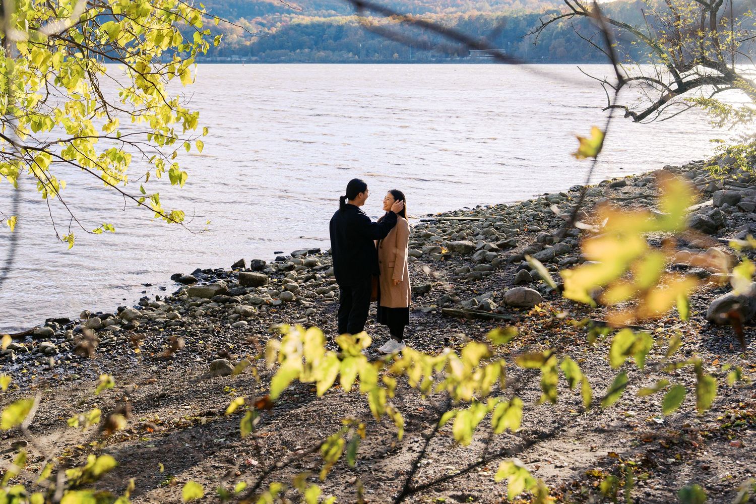 Scenic waterfront view with yellow autumn leaves framing the shoreline.