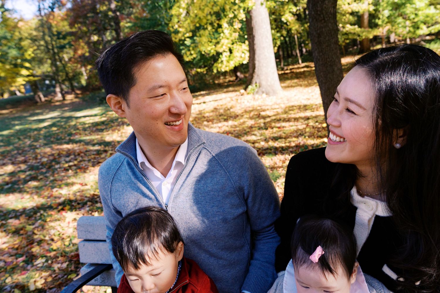 Family sharing happy moment together on autumn day in park setting.