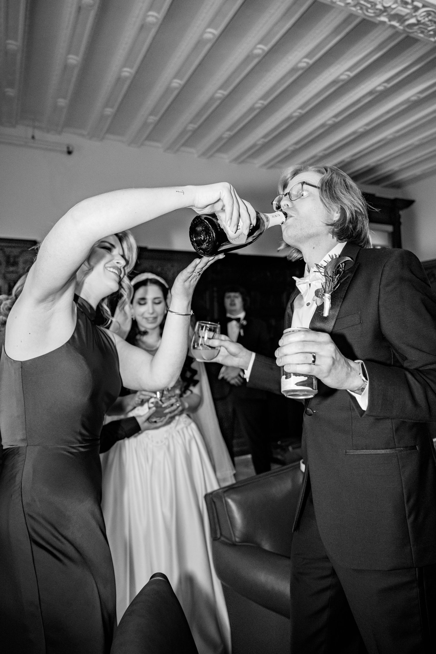 Black and white photo series showing wedding party guests chugging drinks in sequence at a reception celebration.