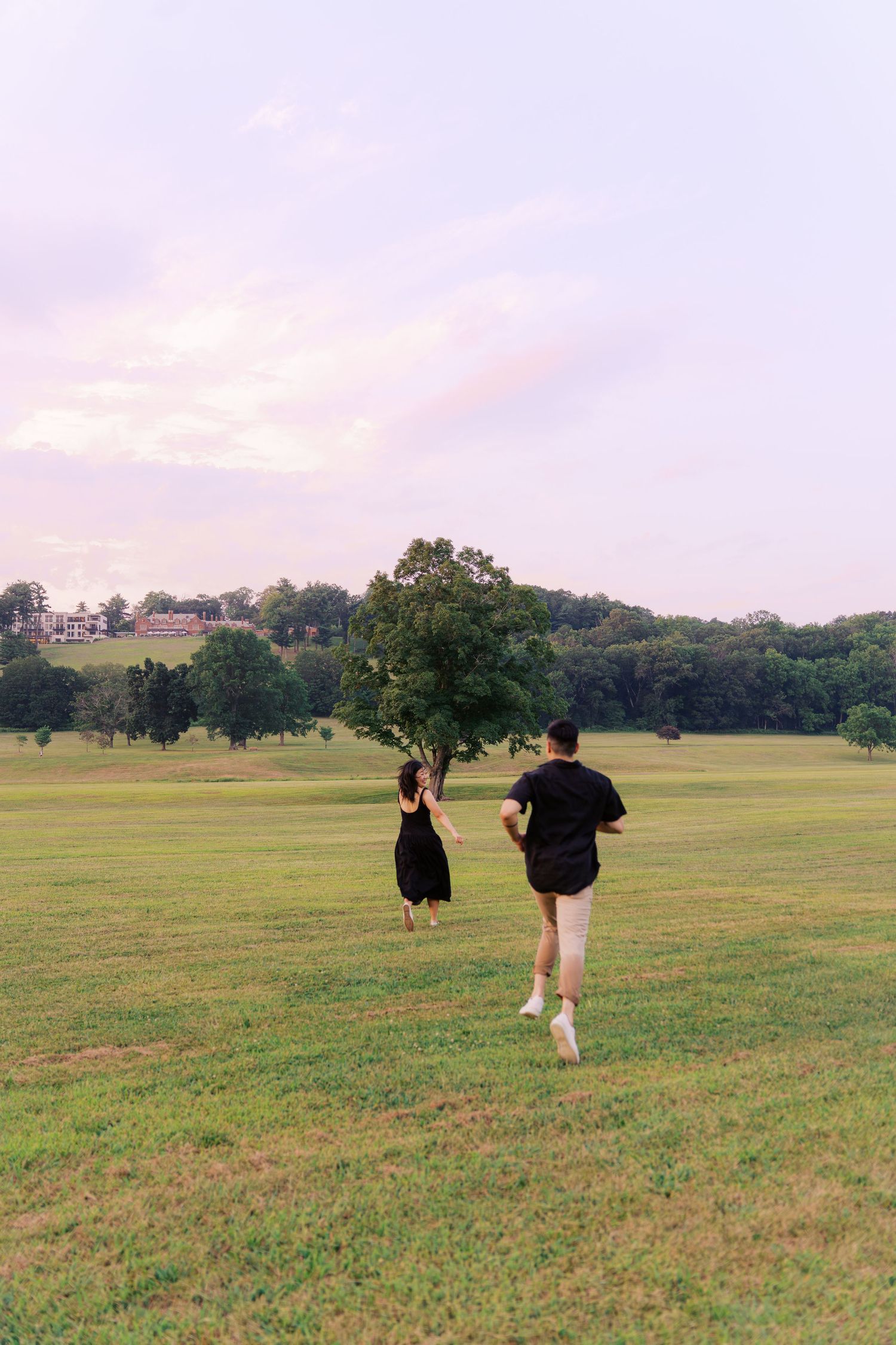 People walking through a serene meadow with trees in the background.