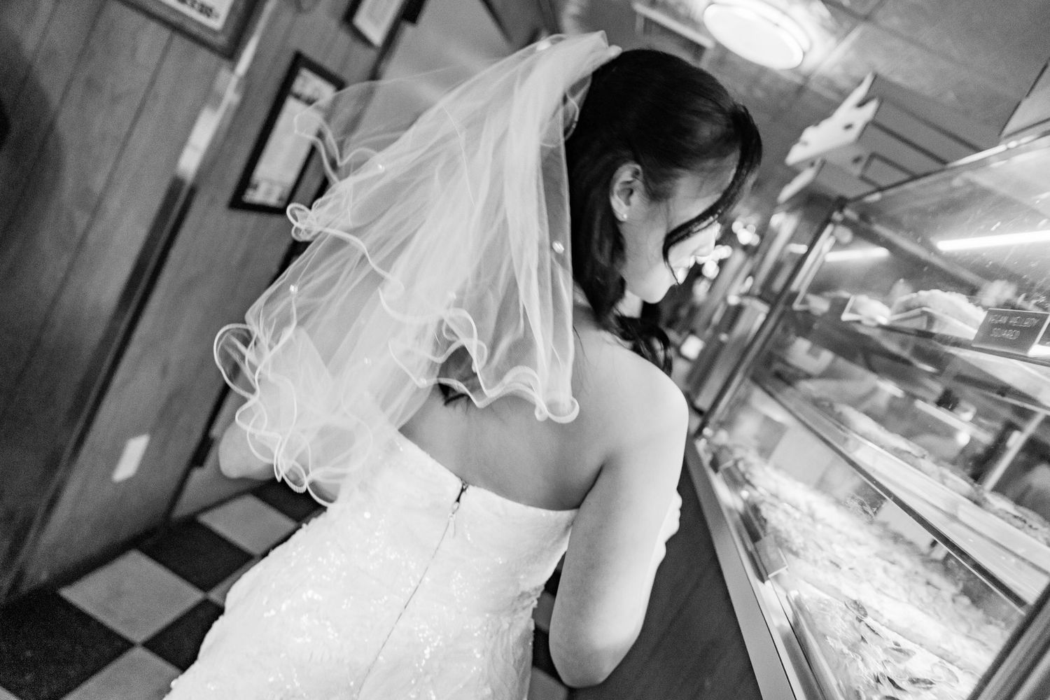 A series of black and white photos showing a bride in a casual diner setting.