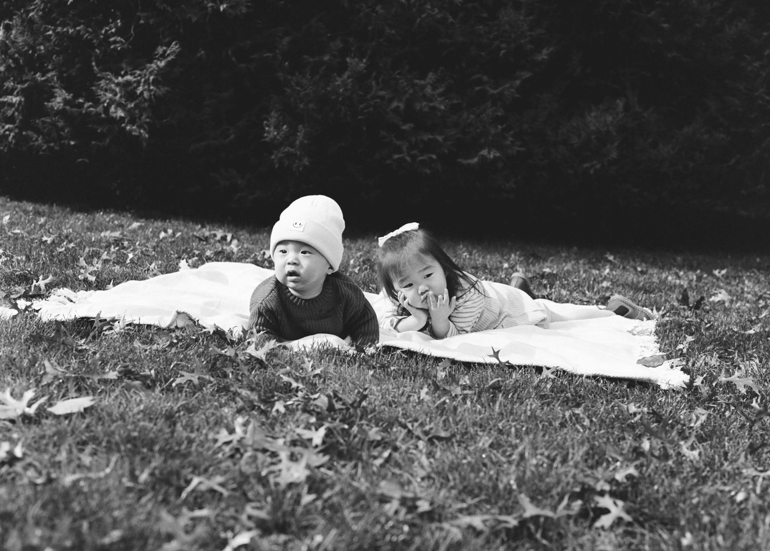 Black and white sequence showing people laying on grass outdoors.