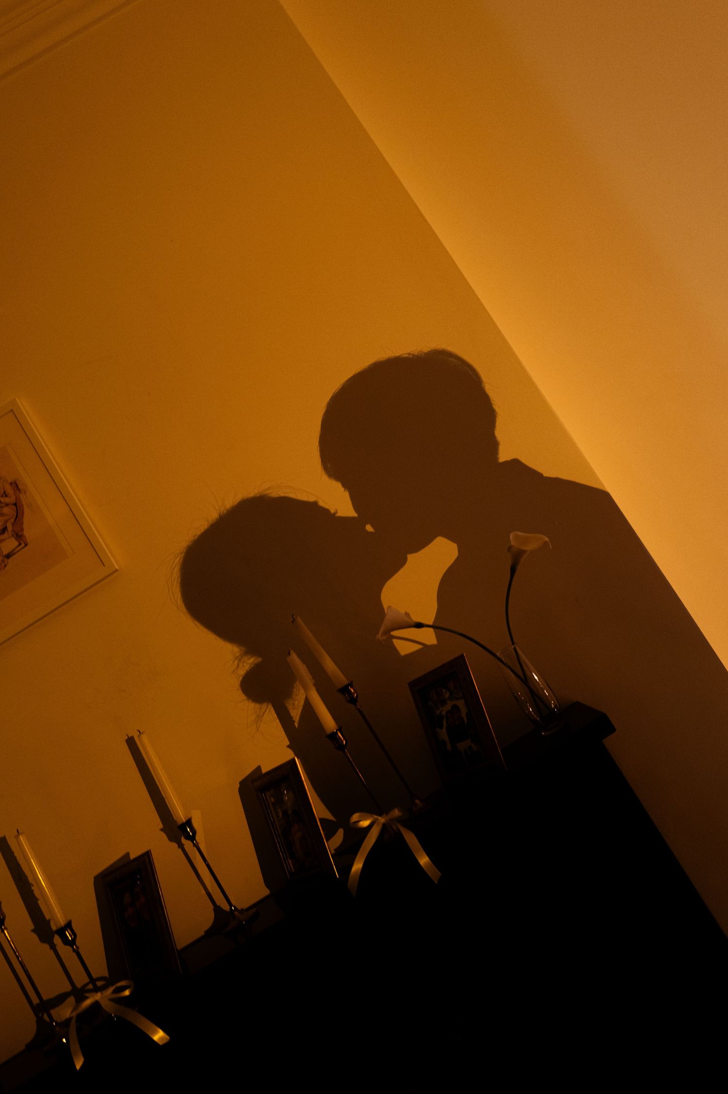 Silhouetted figures against warm orange lighting creating dramatic shadows.
