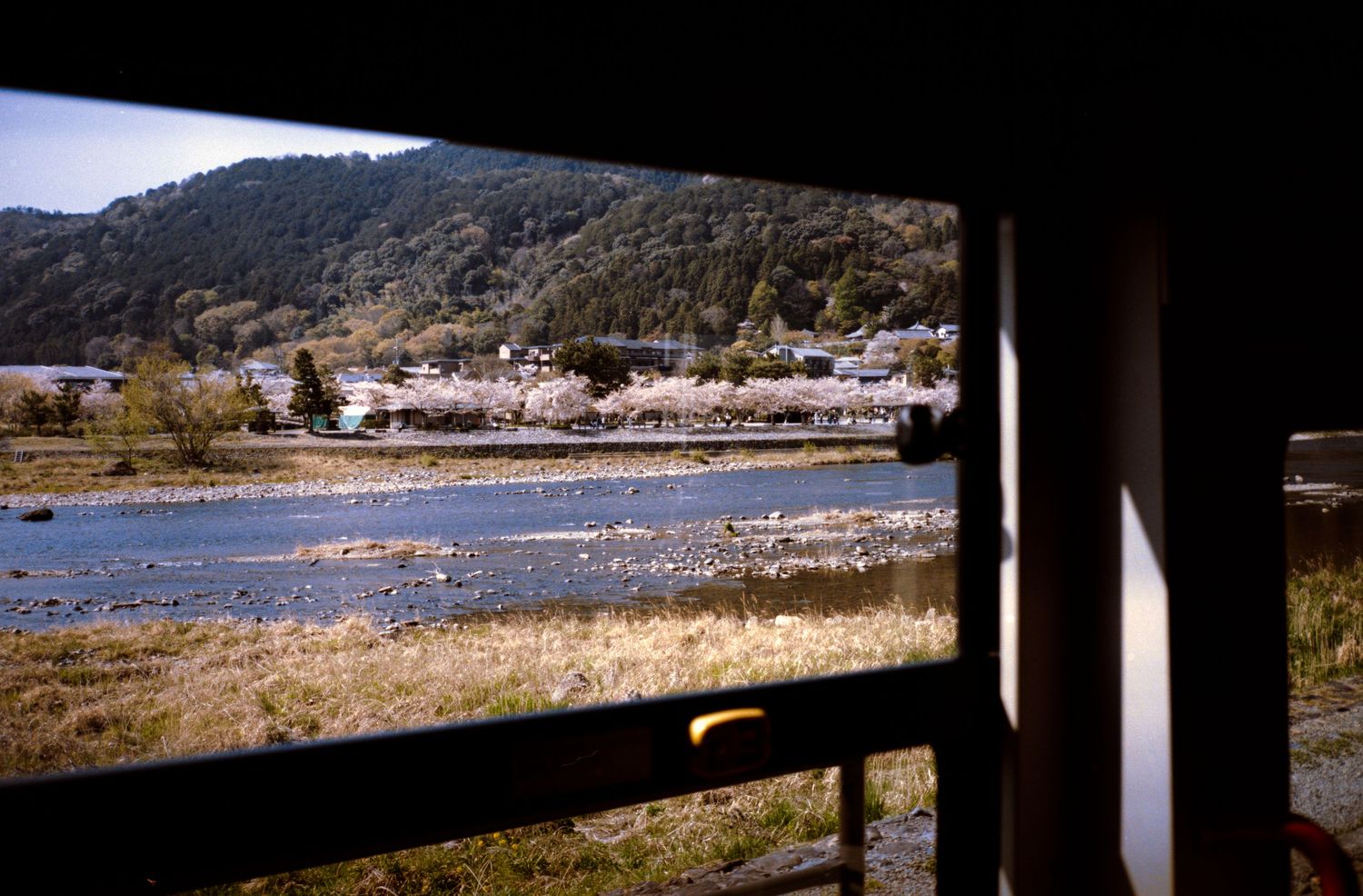 Scenic view of a river and mountains through a window frame or opening.