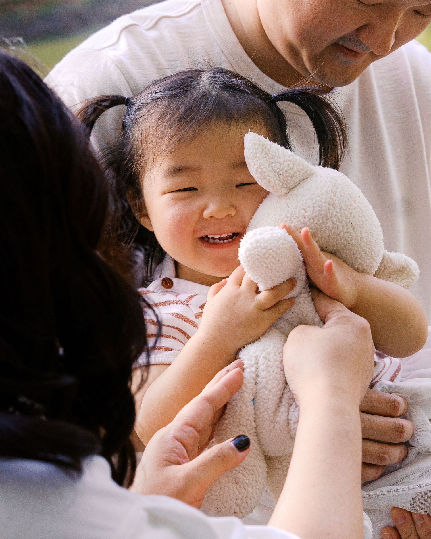 Joyful moment with a soft plush toy being shared outdoors.