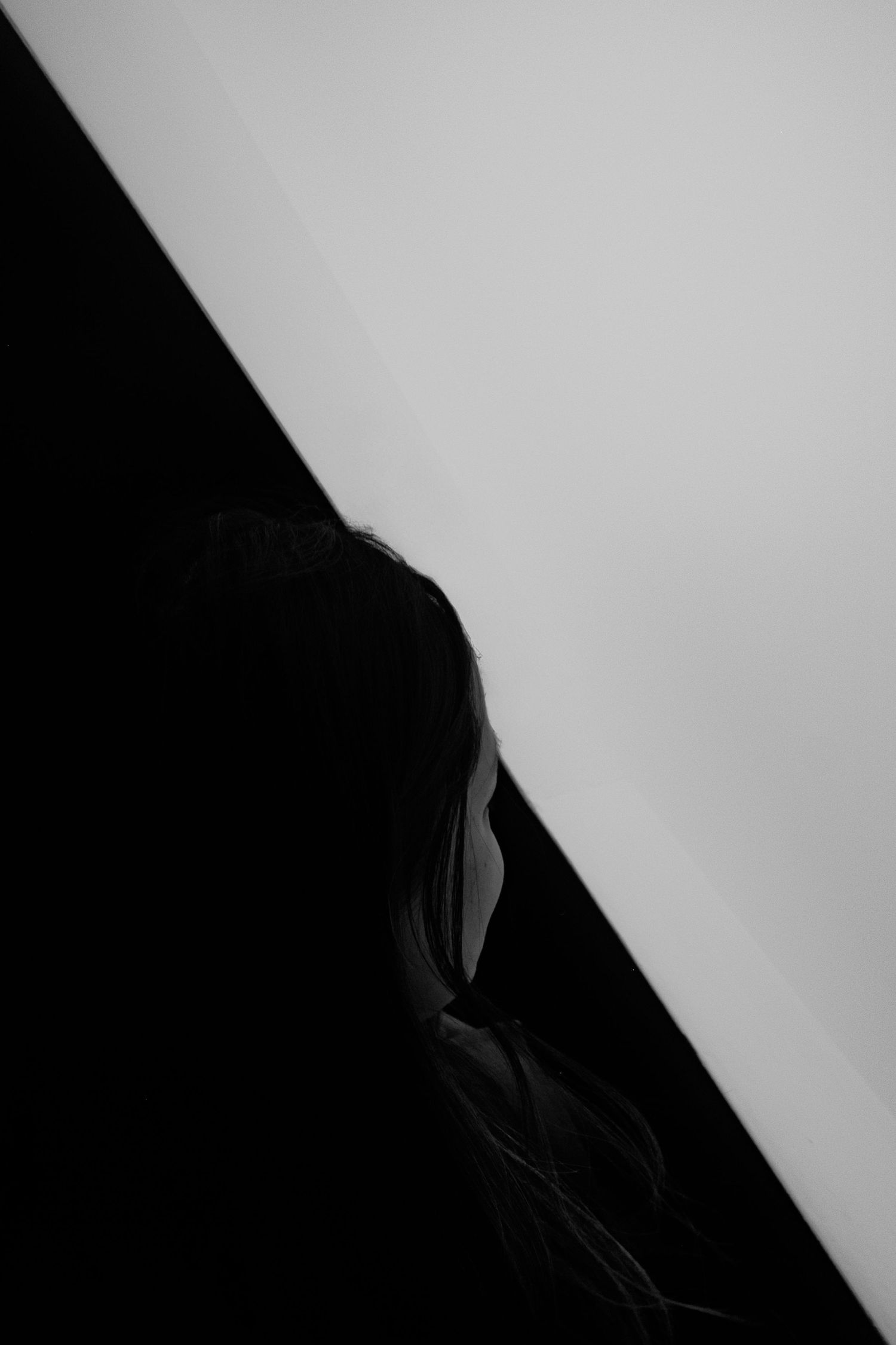Diagonal black and white abstract composition with sharp angular lines creating a minimalist geometric pattern.