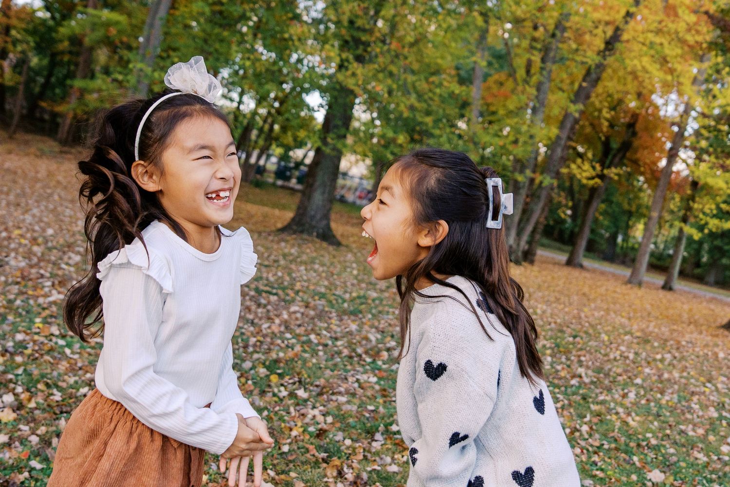 Playful family moments captured in sequence on a leaf-covered ground during fall.
