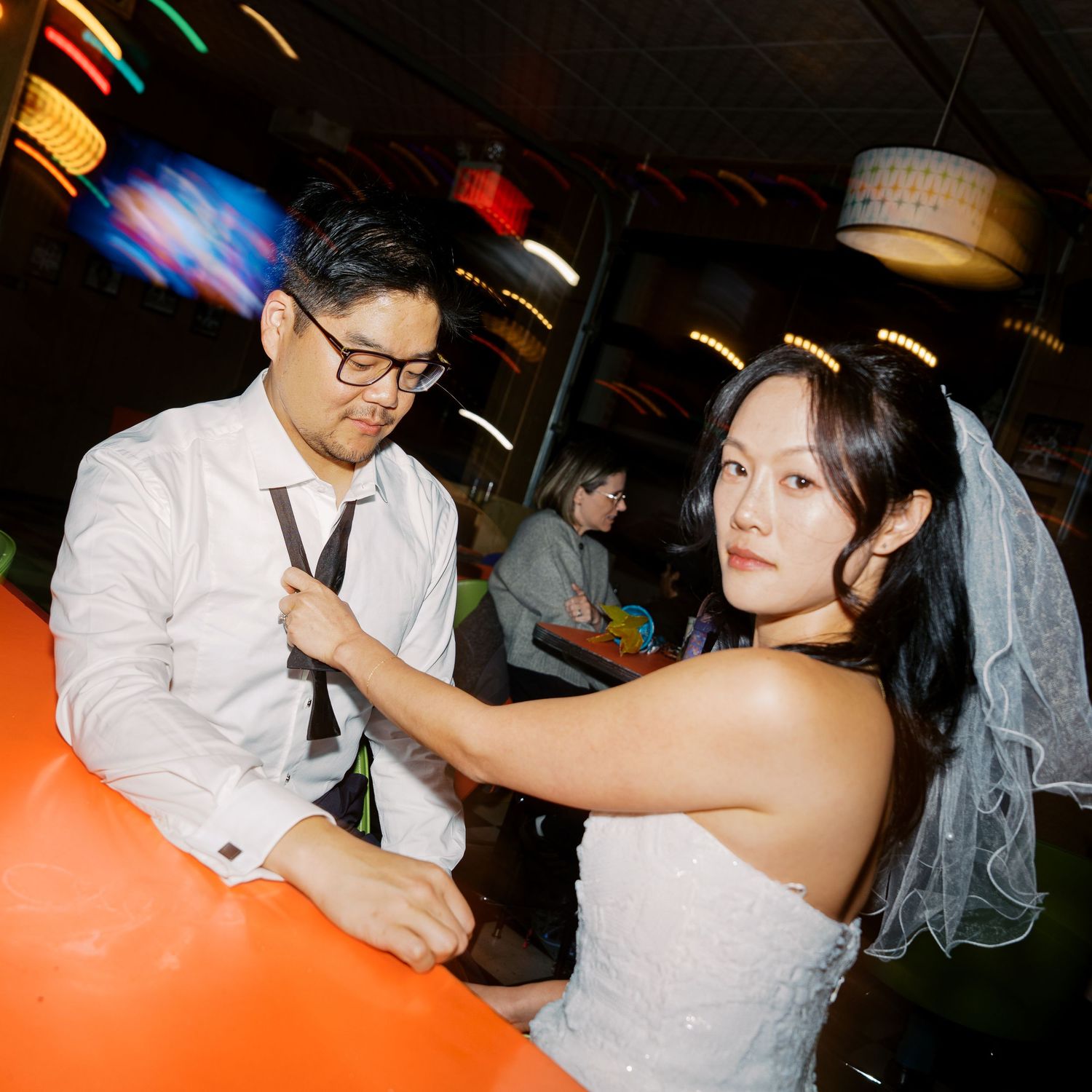 A wedding reception scene with orange ambient lighting and festive decorations.