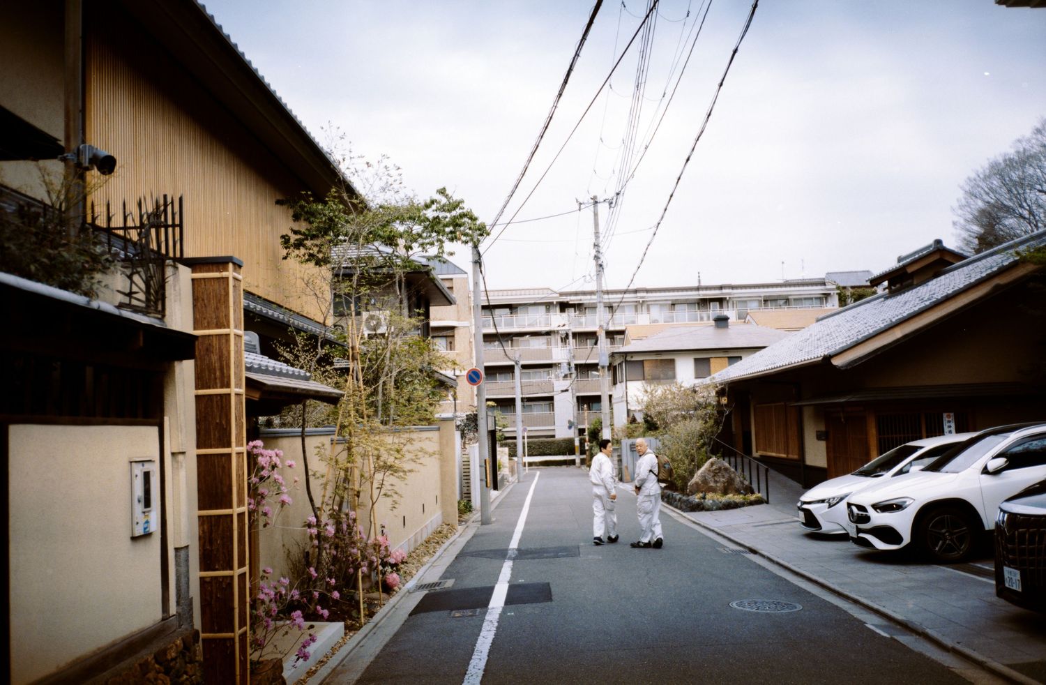 A residential street in Japan with modern apartments and traditional houses.
