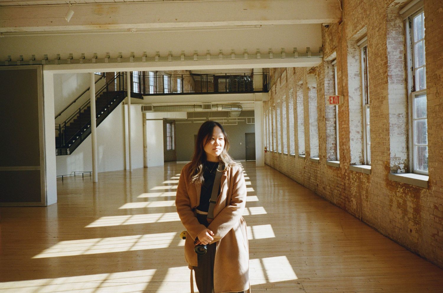 Sunlight streams through windows in a long corridor creating dramatic shadows and patterns on the floor.