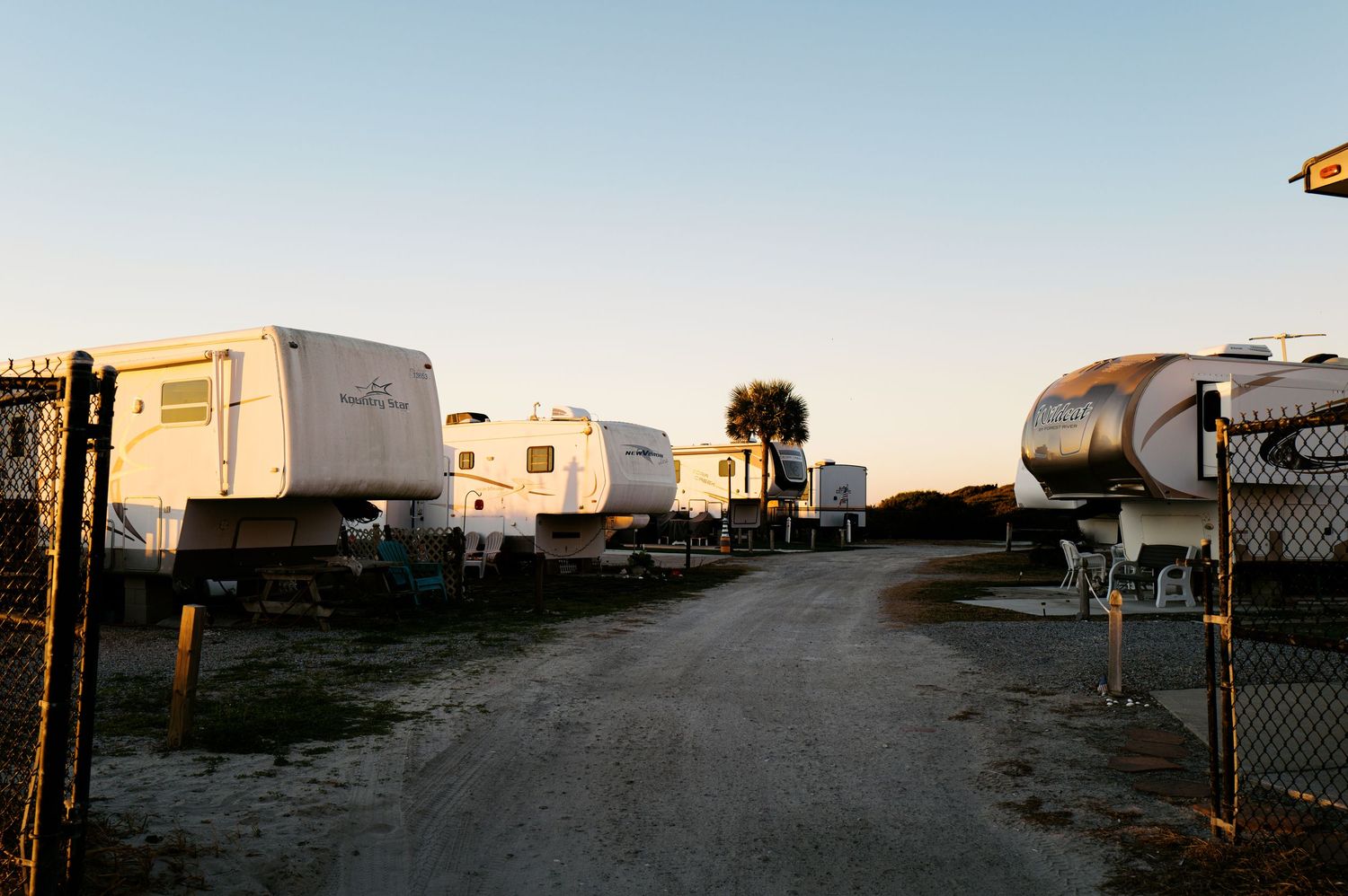 Panoramic view of a desert mobile home park with trailers and RVs at sunset.
