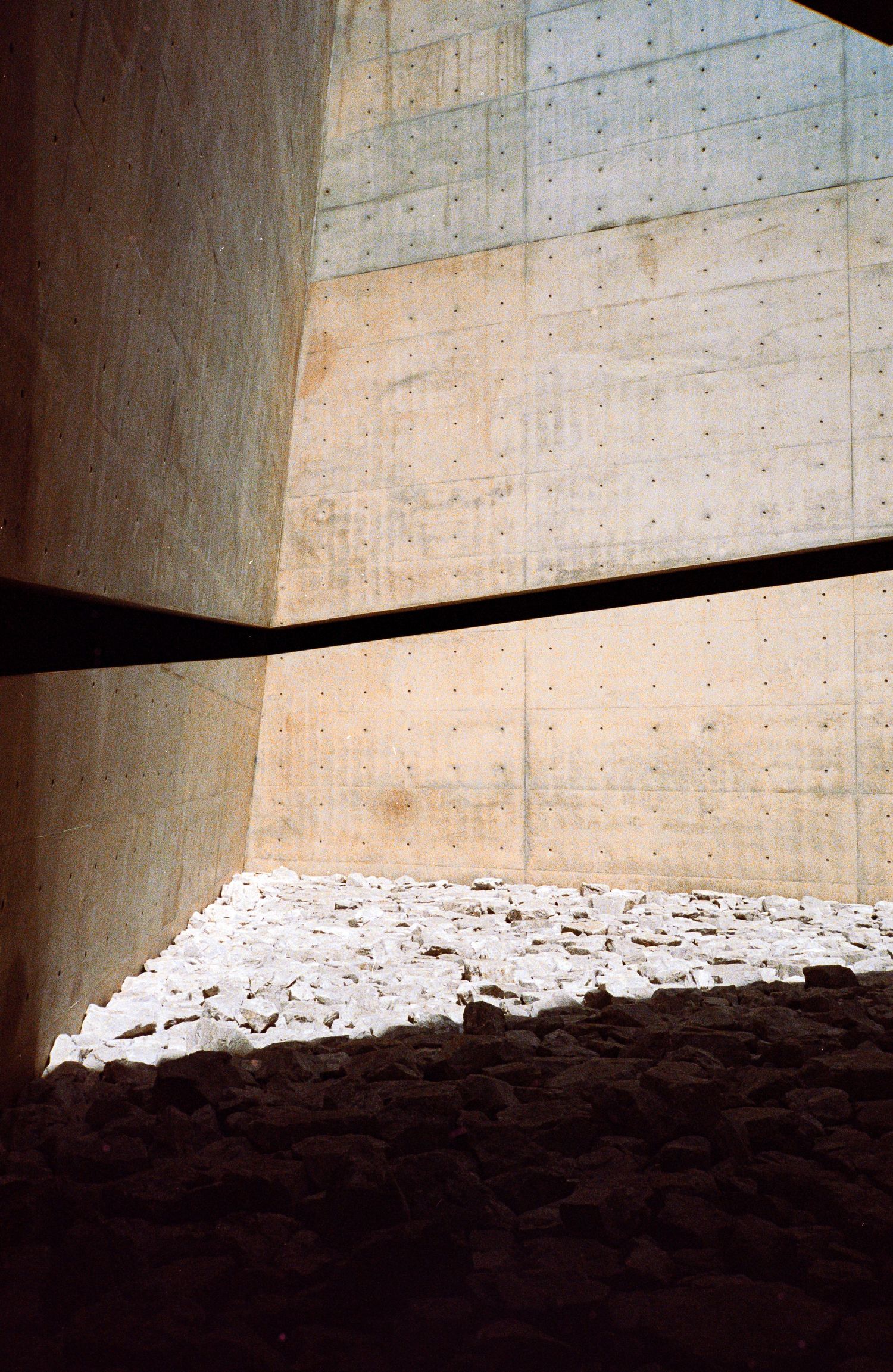 Abstract architectural detail of concrete walls with dramatic shadows and light patterns.