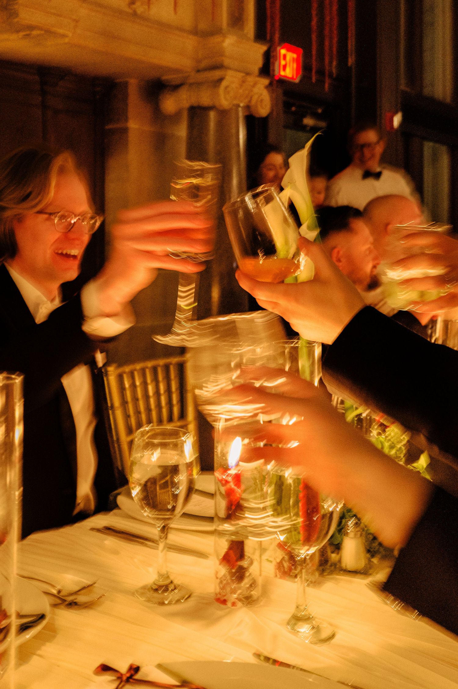 People dining at an elegant restaurant table with glassware and warm lighting creating an intimate atmosphere.