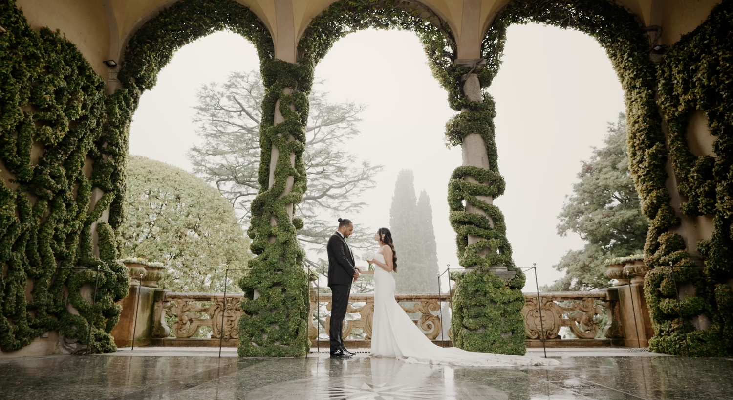 Wedding couple standing under stone archway covered in lush green ivy. Villa del Balbianello. Lake Como. Lake Garda. Wedding.