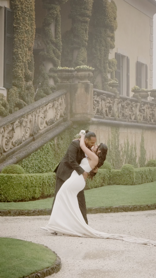 Romantic dip pose between couple in wedding attire against ornate garden backdrop. Villa del Balbianello. Lake Como. Lake Garda. Wedding.