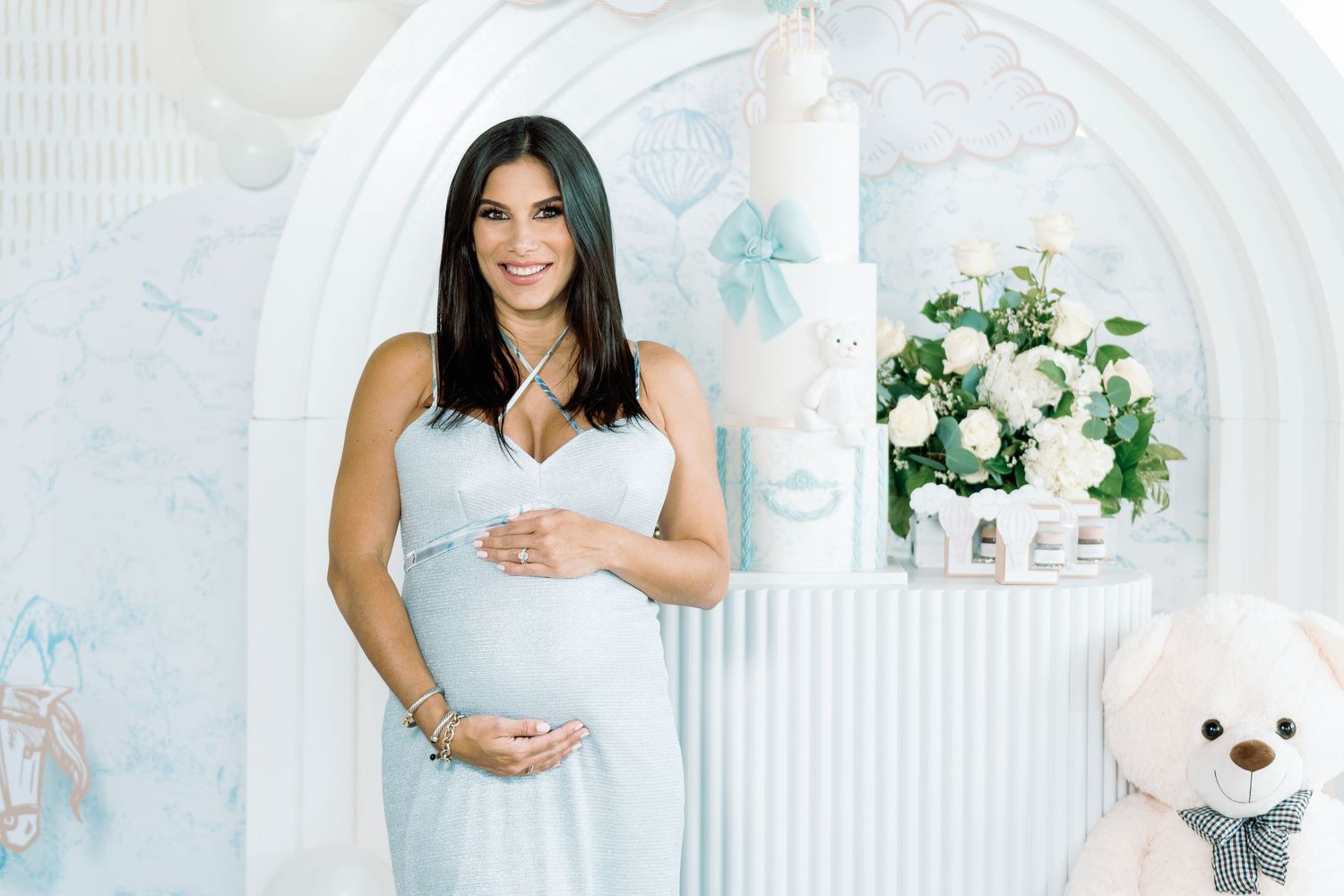 White curved backdrop with soft decor elements creates elegant photo setting.