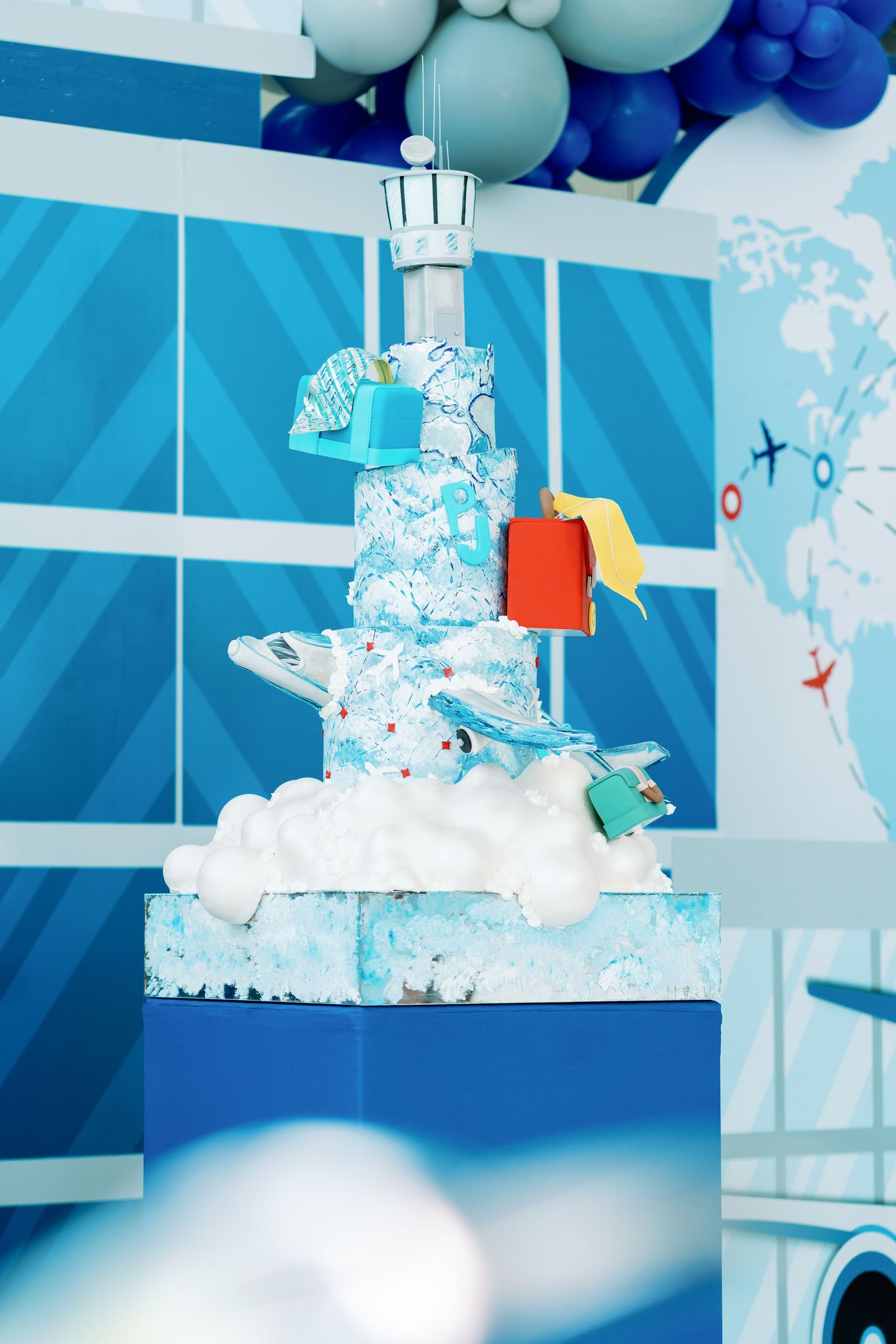 Modern blue-themed party decoration with balloon arrangements and geometric backdrop design.