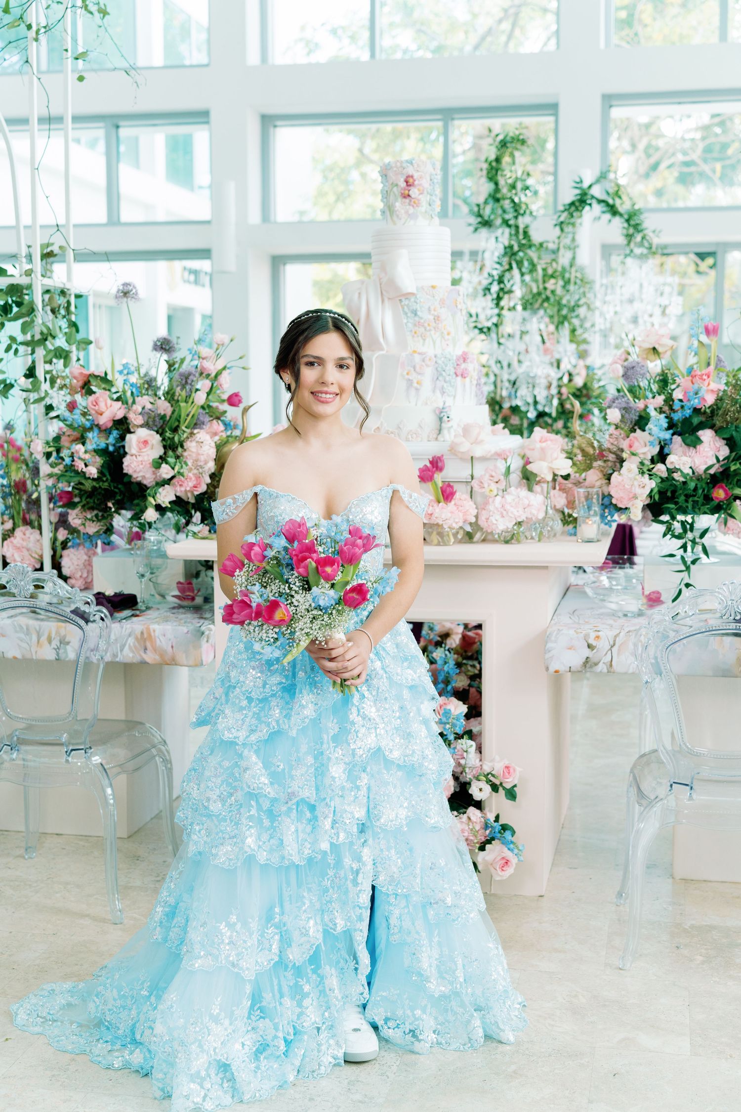 Elegant event space decorated with blue tulle and pink floral arrangements.