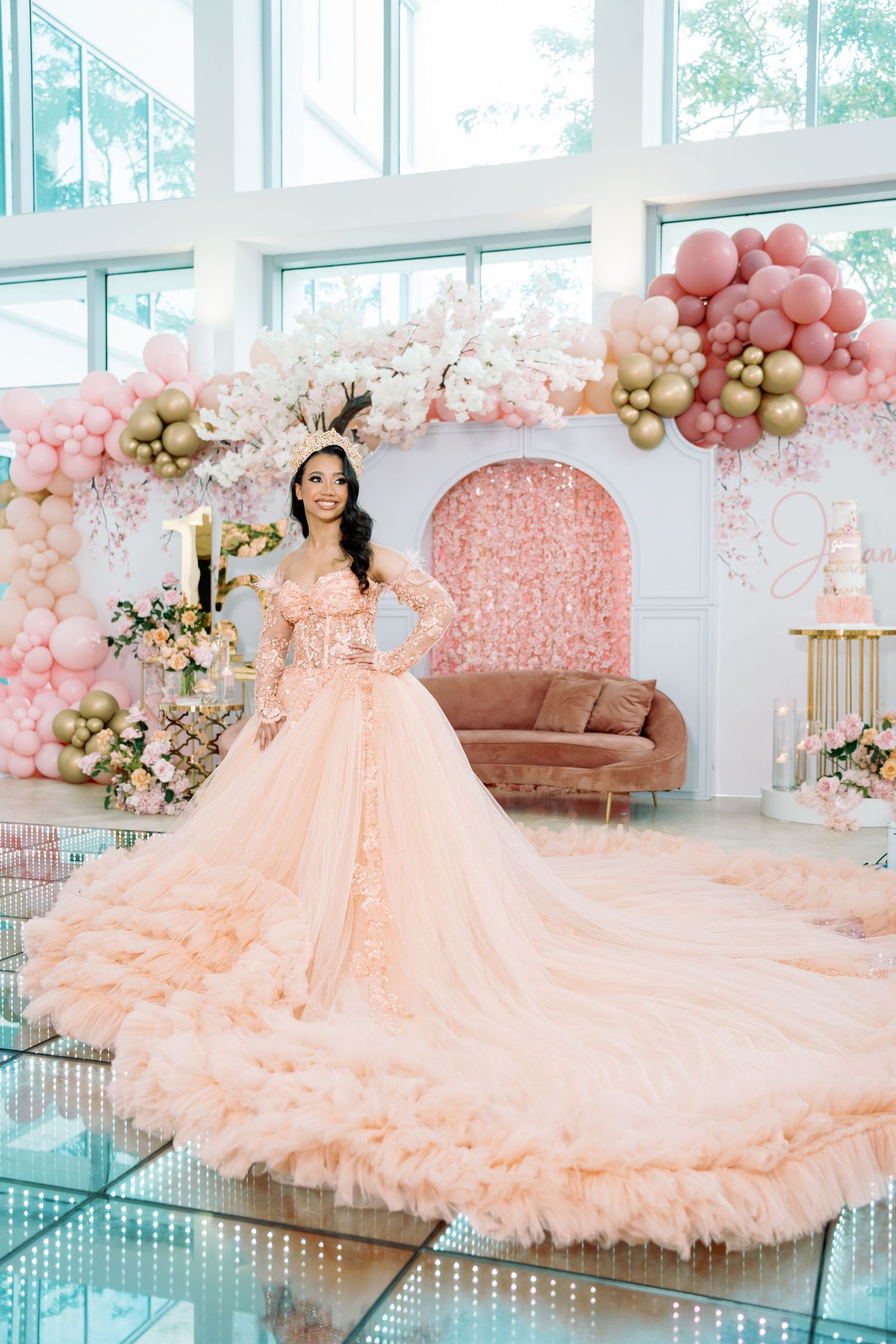 Luxurious pink ballgown dress displayed in a room decorated with pink and gold balloon arrangements.