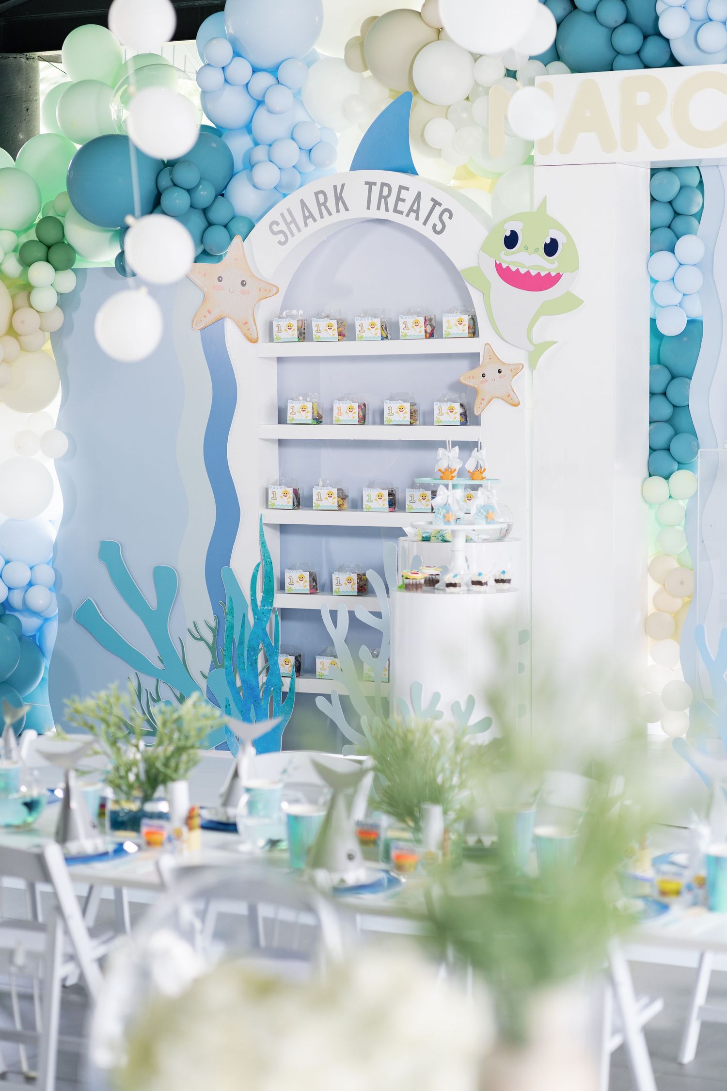 Underwater themed party space with blue balloon garlands and sea creature decorations.