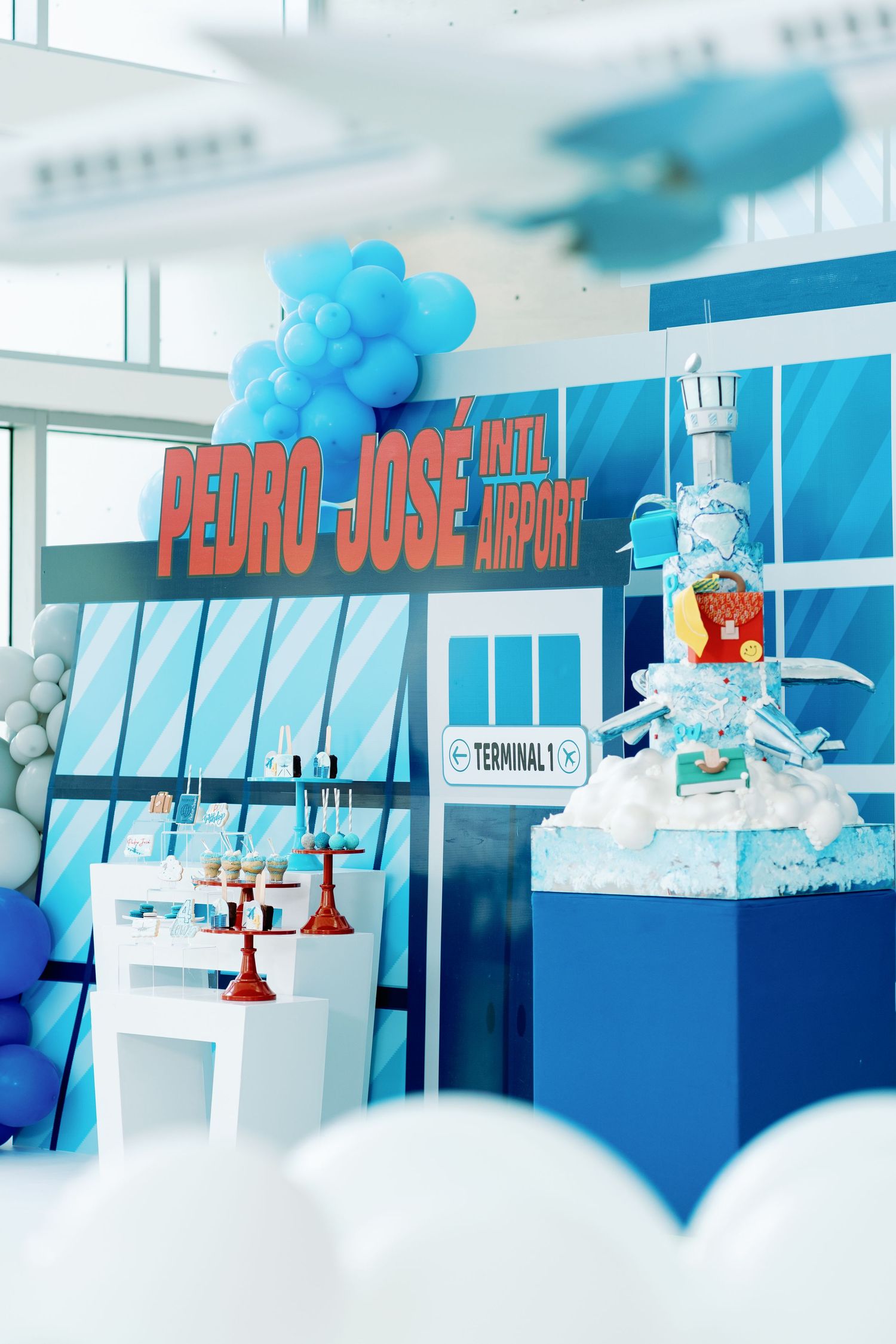Blue and white party setup with balloon decorations and 'Pedro Jose' text display.