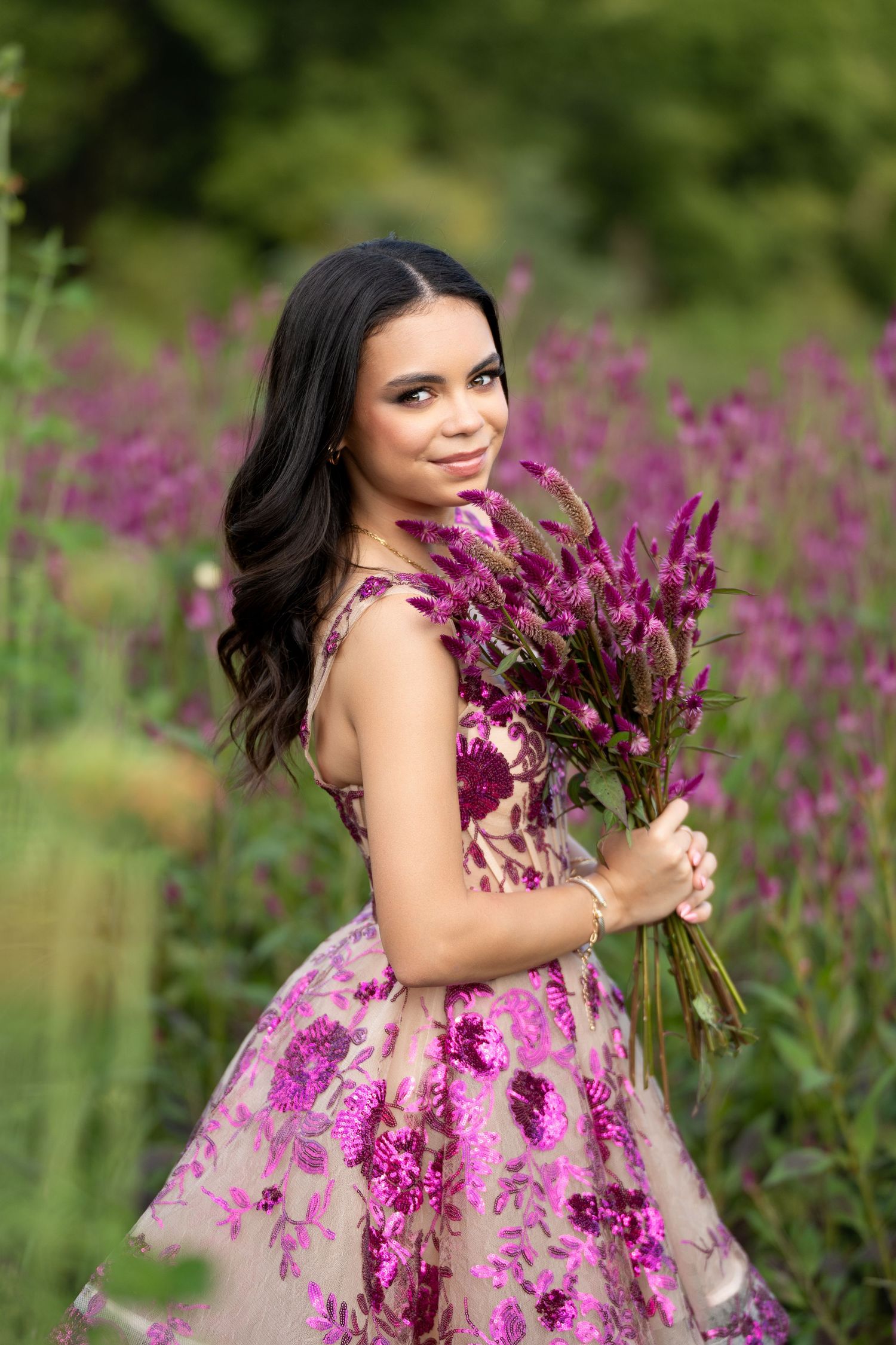 Dreamy outdoor maternity photos among purple flowers in a garden setting.