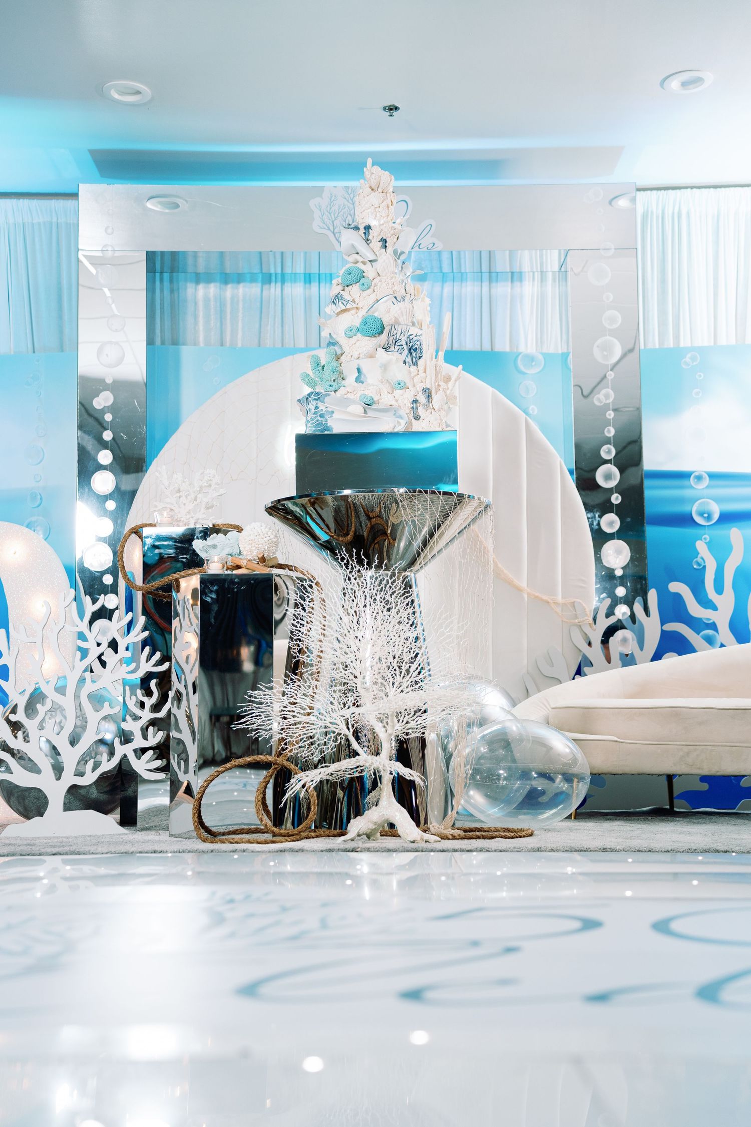 Modern winter wonderland decor featuring white coral-like sculptures and glass elements against a blue backdrop.