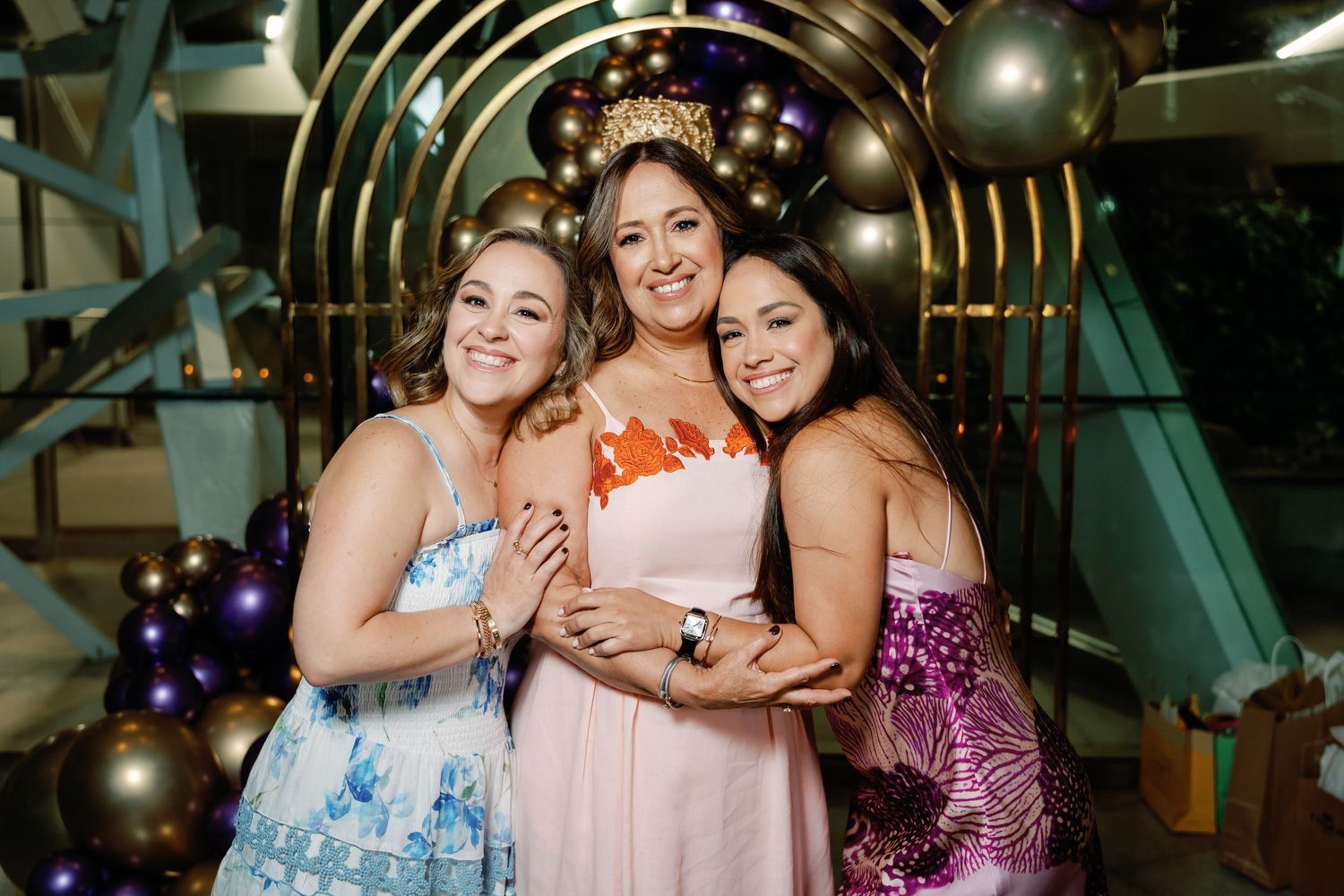 Festive party scene with gold and purple balloons and elegant evening attire.