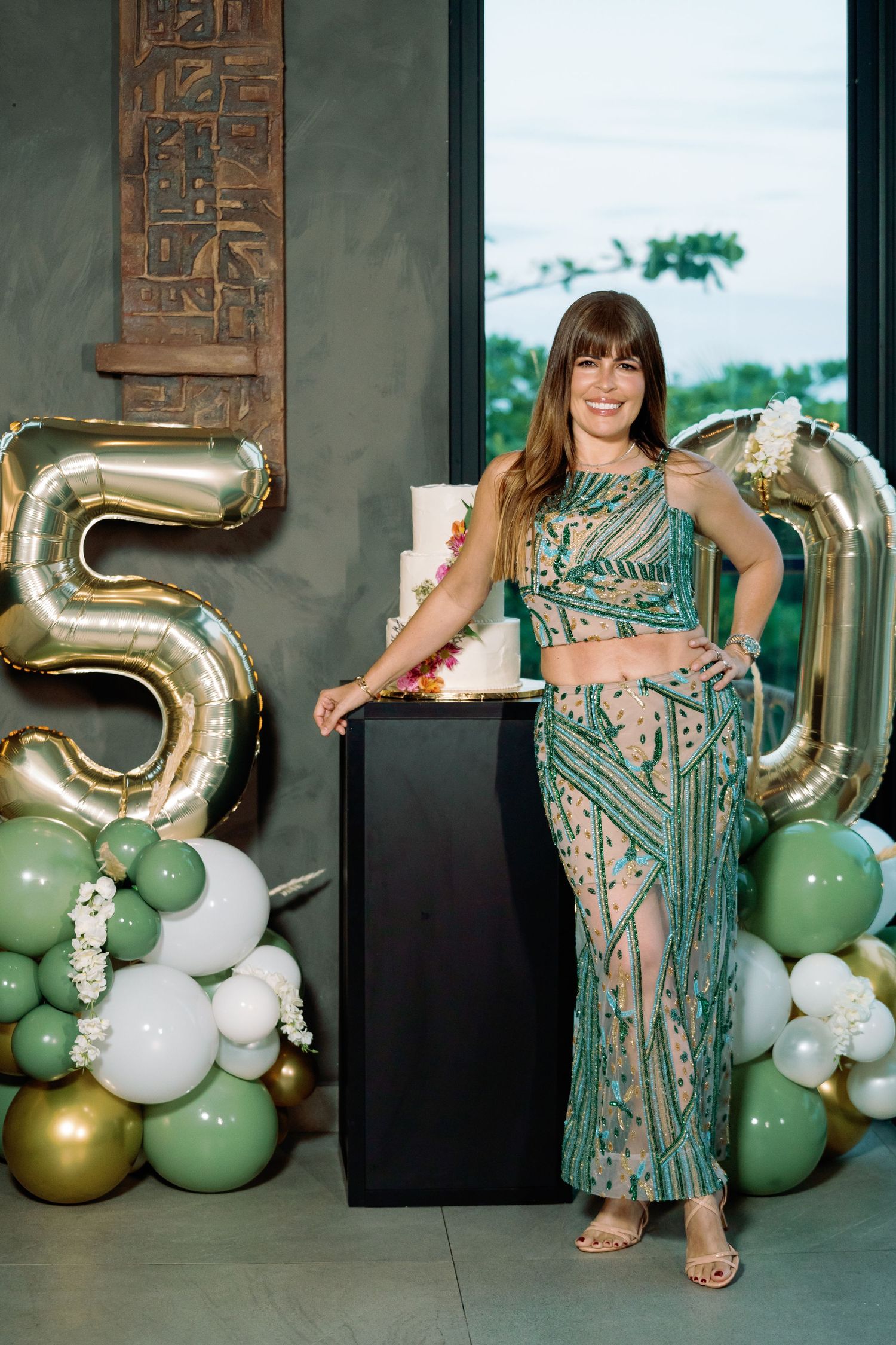 Sparkly green sequined dress photographed with gold number balloons and mint green decorations.