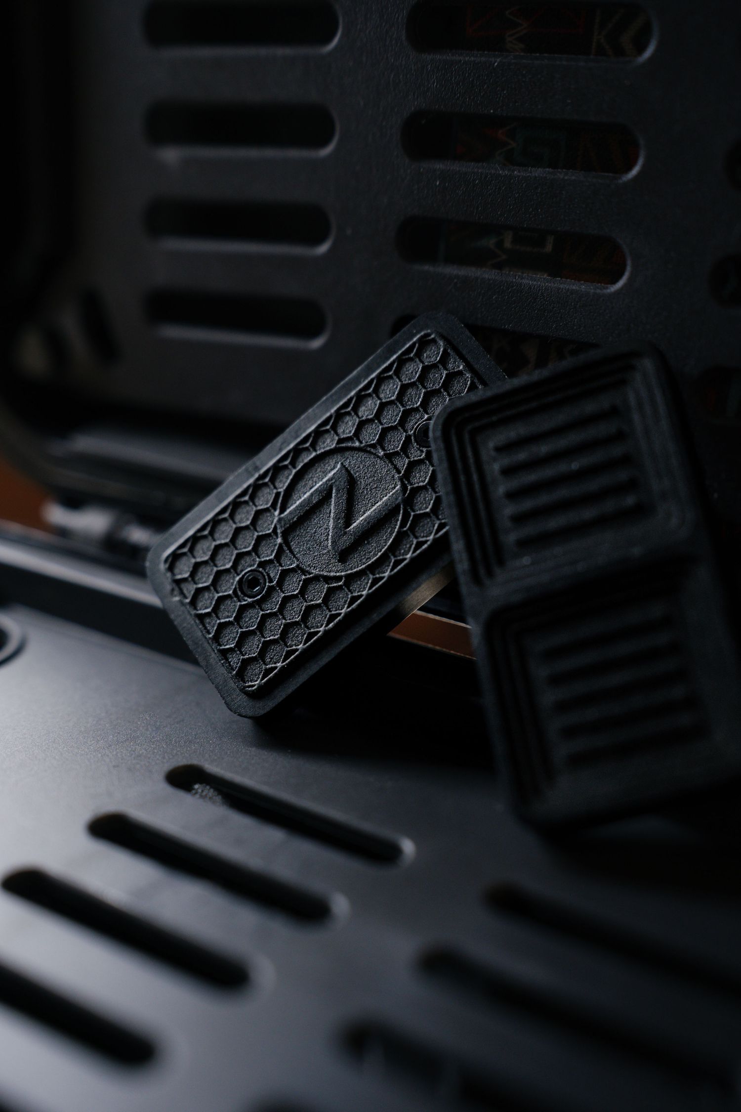 Product photography of Black rubber Noctua PC case feet with hexagon pattern stacked on computer case.