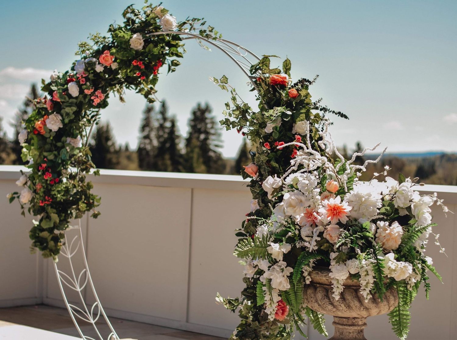 Beautiful floral wedding arch adorned with colorful blooms on a rooftop with mountain views.