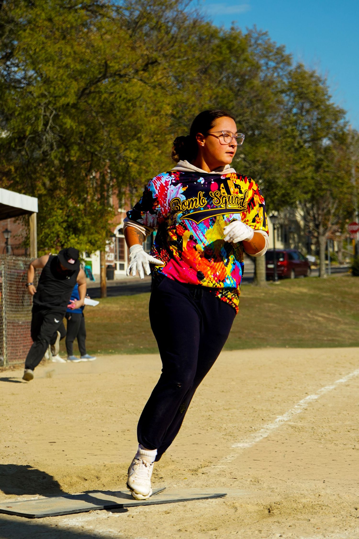 Dynamic action shot of a woman running outdoors on a sunny day, showcasing softball photography