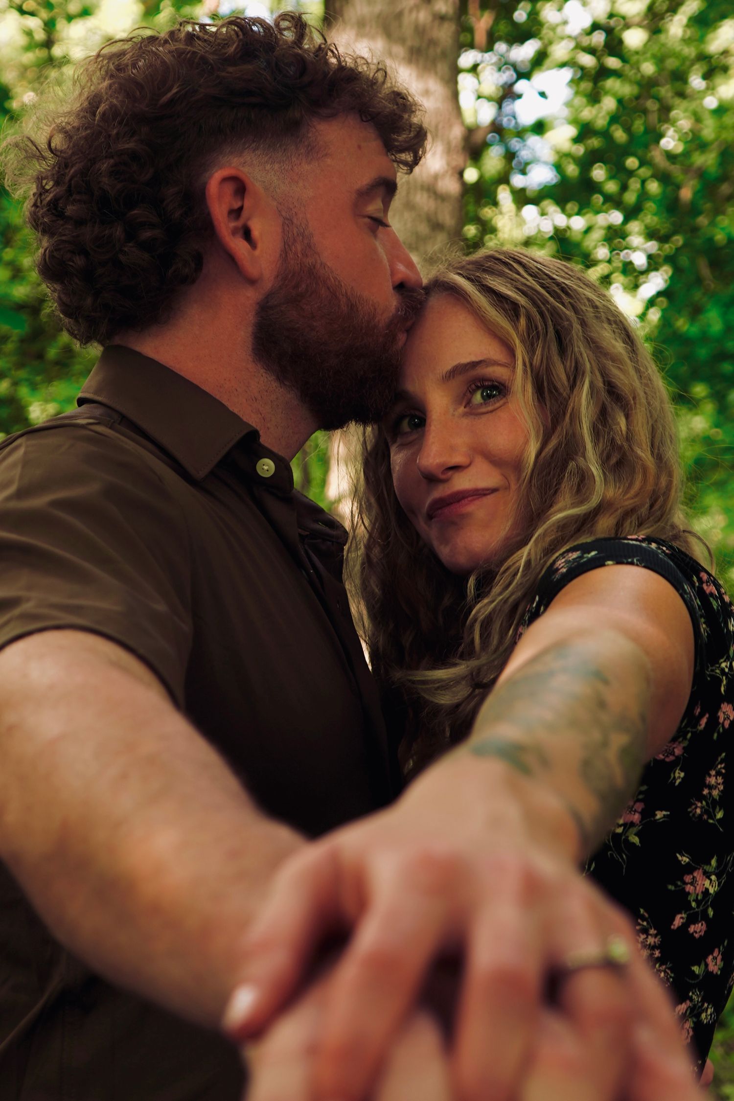 Romantic engagement portrait of a couple embracing outdoors in a wooded, natural setting
