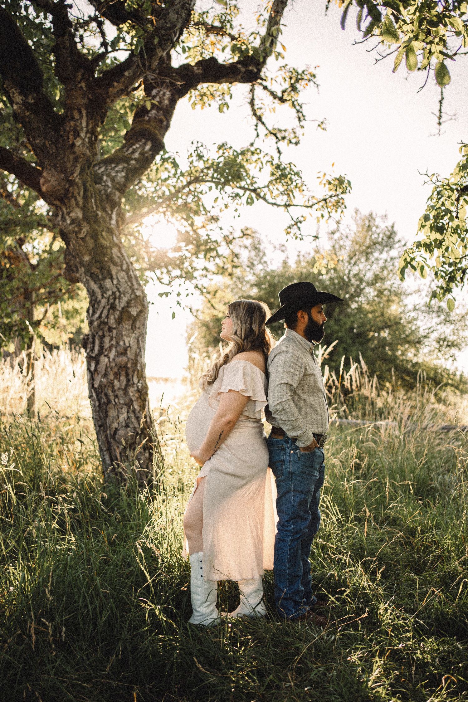Family sharing tender moments under trees during a sunset photo session.