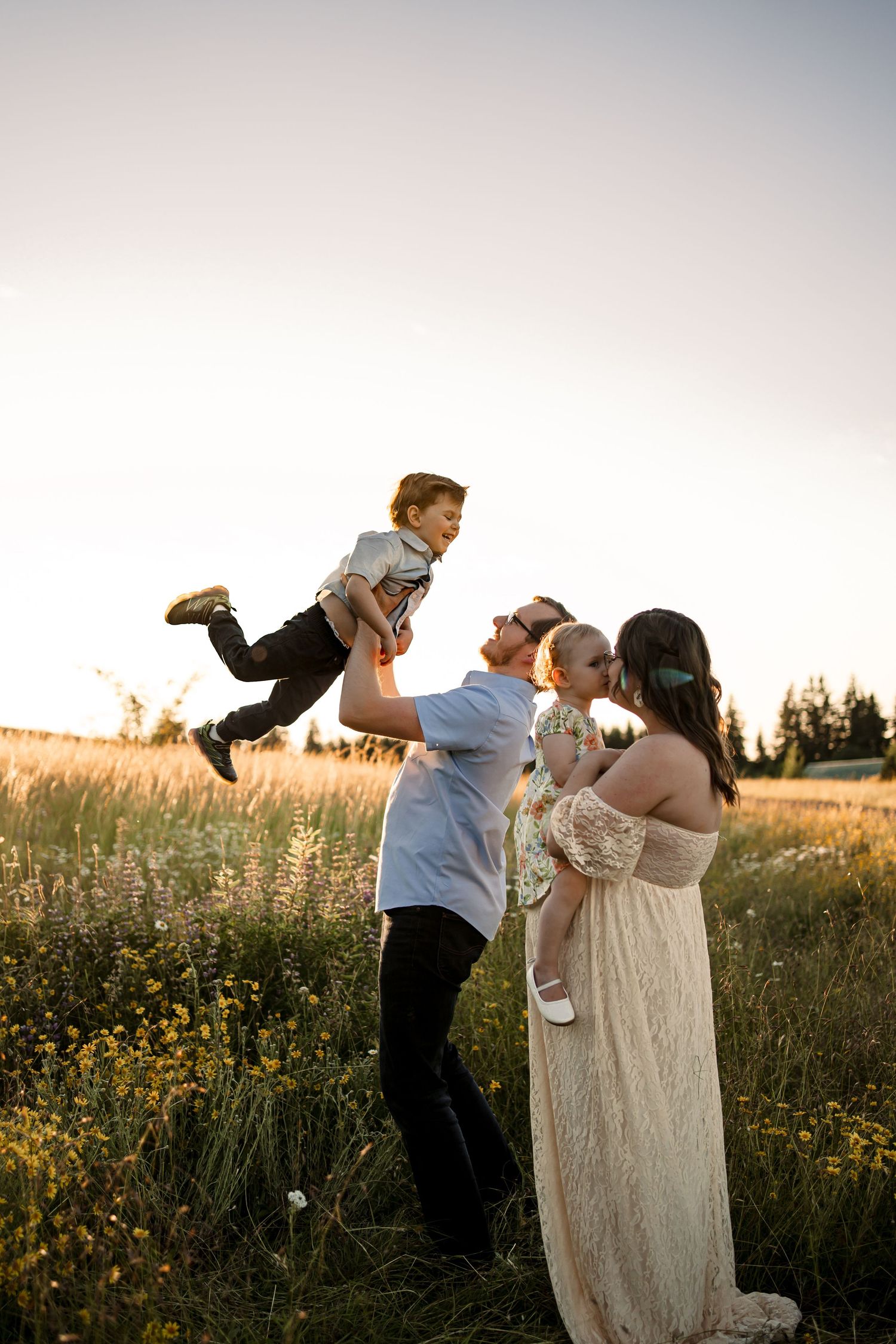 Playful family photoshoot in a wildflower field at sunset.