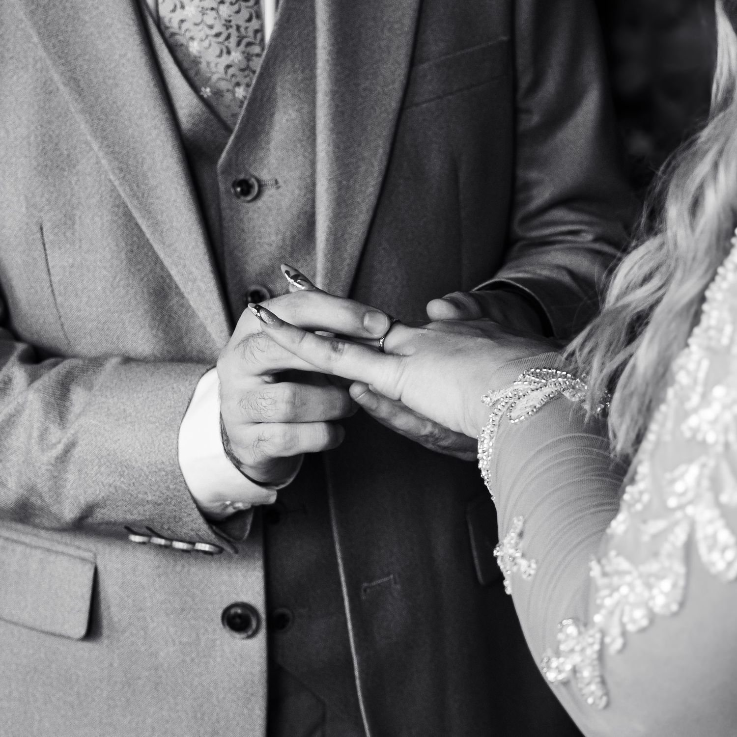 Black and white photo showing the exchange of wedding rings