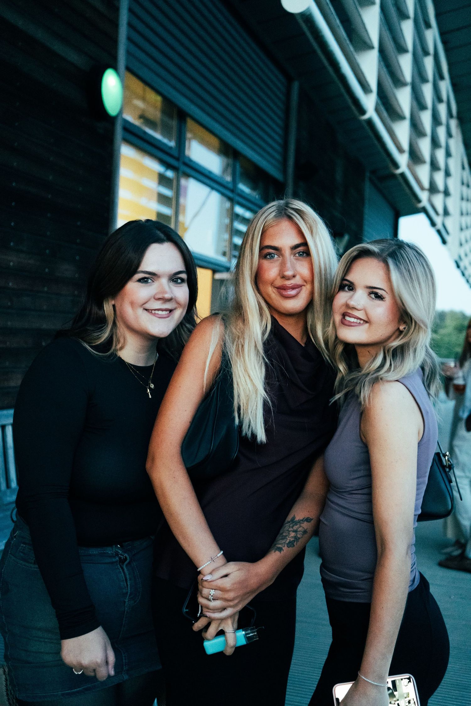 A series of candid photos showing friends laughing and embracing in a casual outdoor setting.
